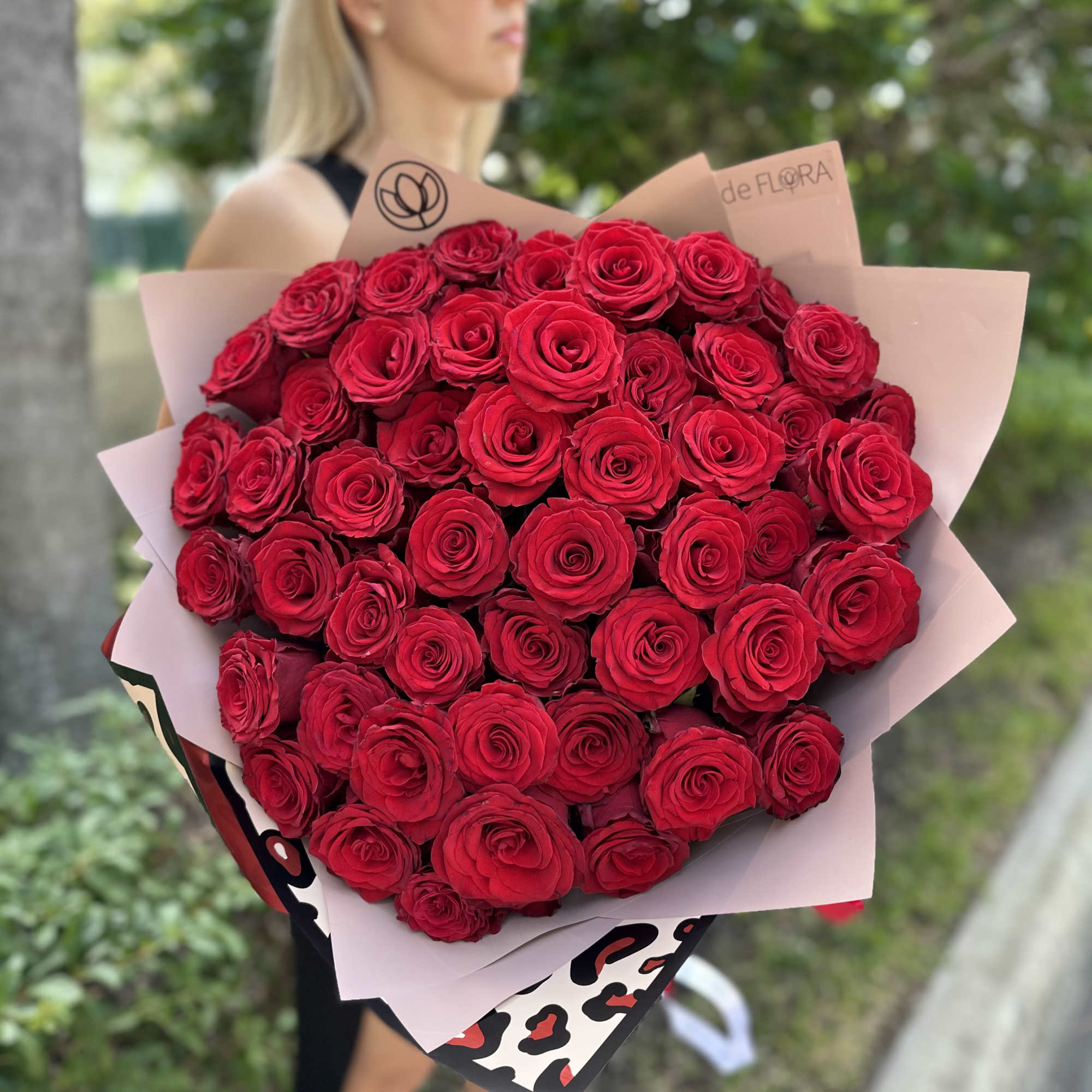 Large bouquet of red roses wrapped in pink paper
