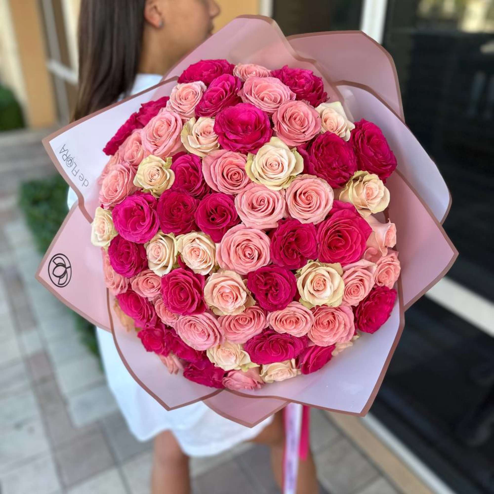 Large bouquet of pink and magenta roses wrapped in pale pink paper