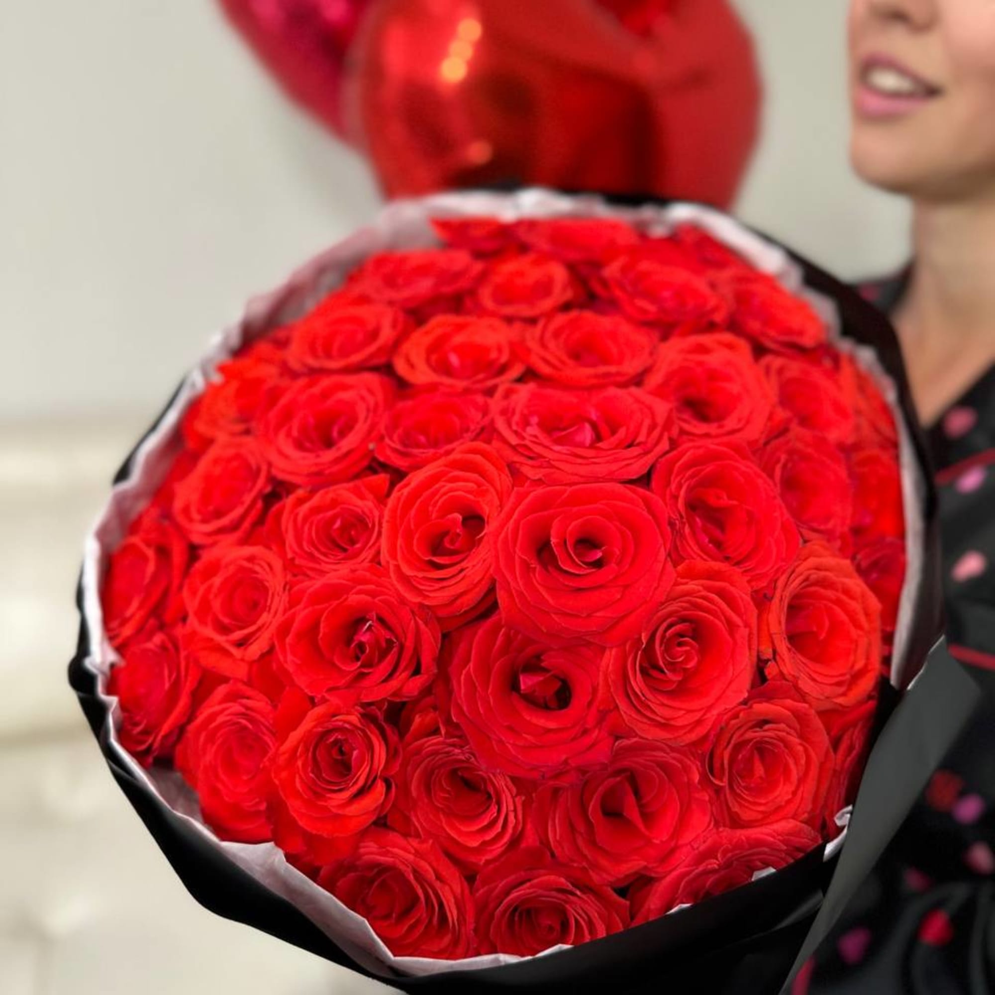Large bouquet of red roses wrapped in black paper