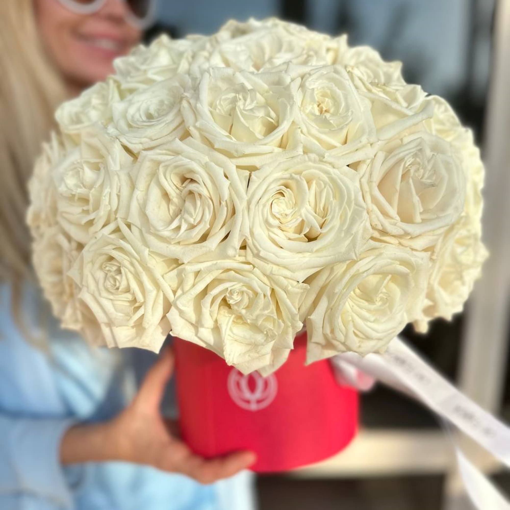 Bouquet of white roses in a red hat box