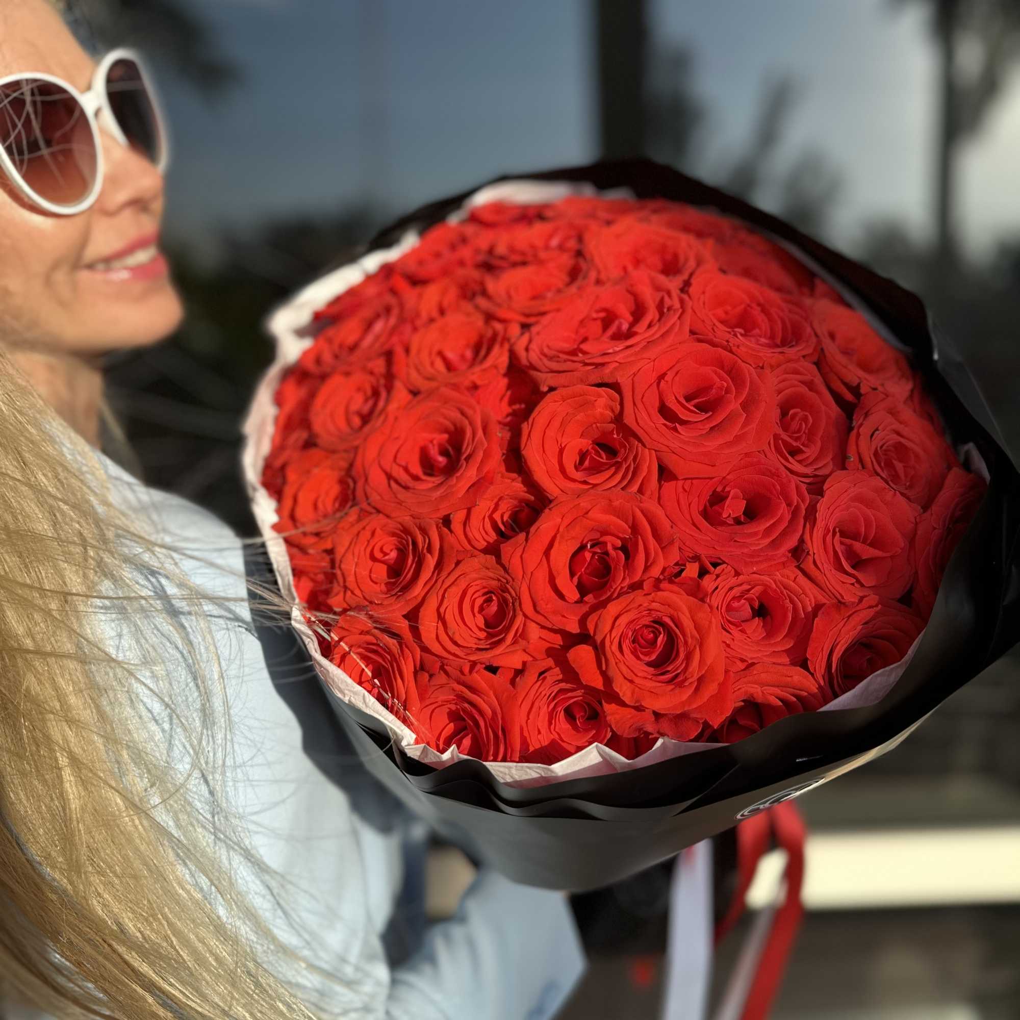 Large bouquet of red roses wrapped in black paper