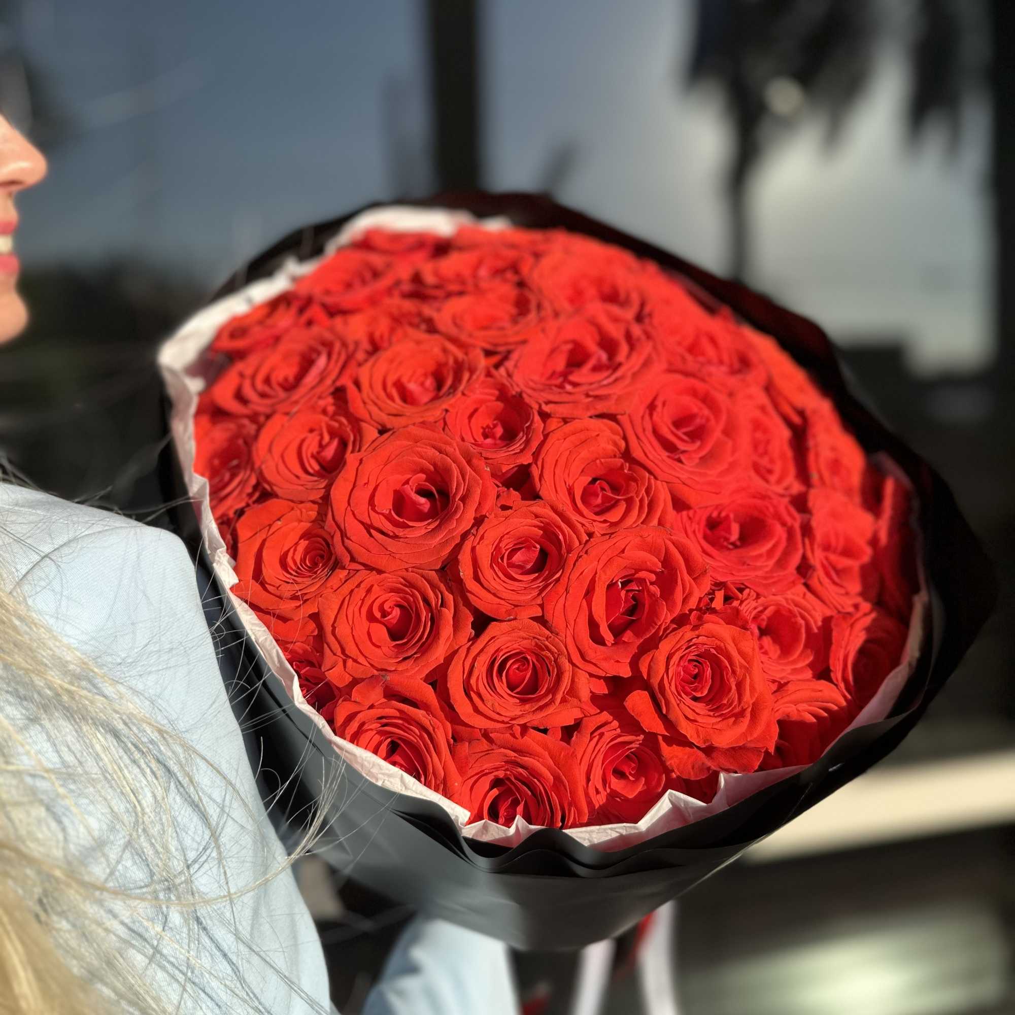 Bouquet of red roses wrapped in black paper