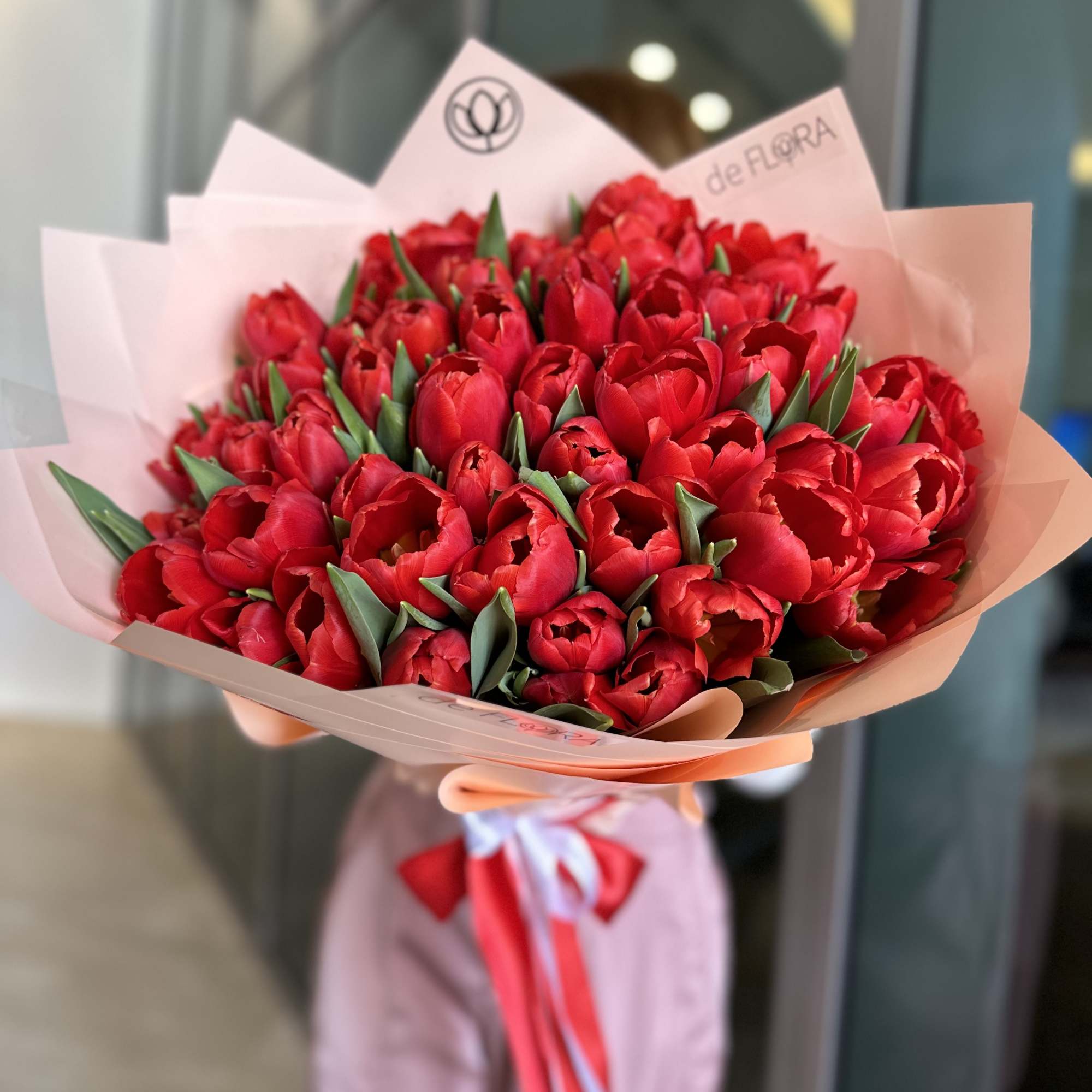 Bouquet of red tulips wrapped in pale pink paper