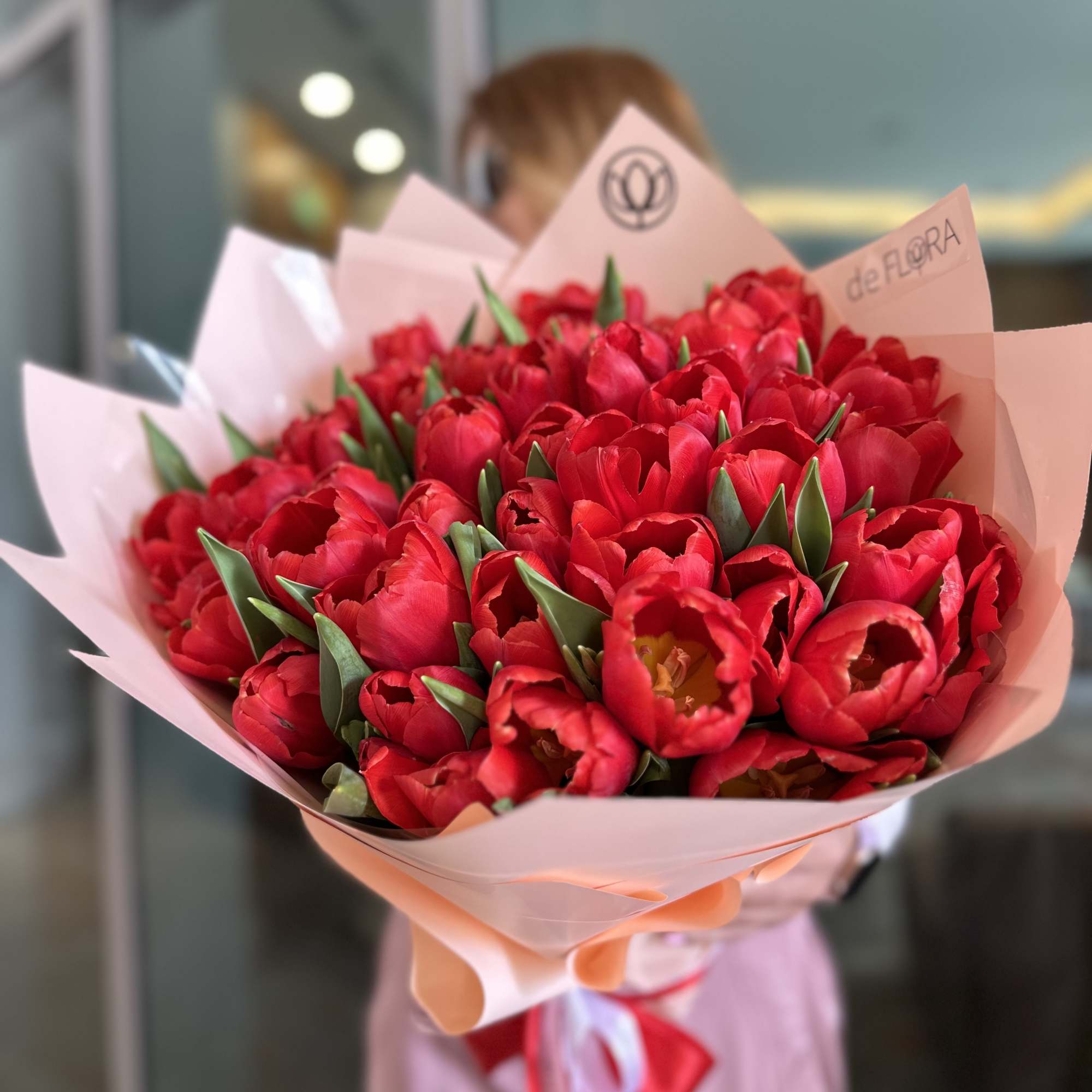 Bouquet of red tulips wrapped in pink paper
