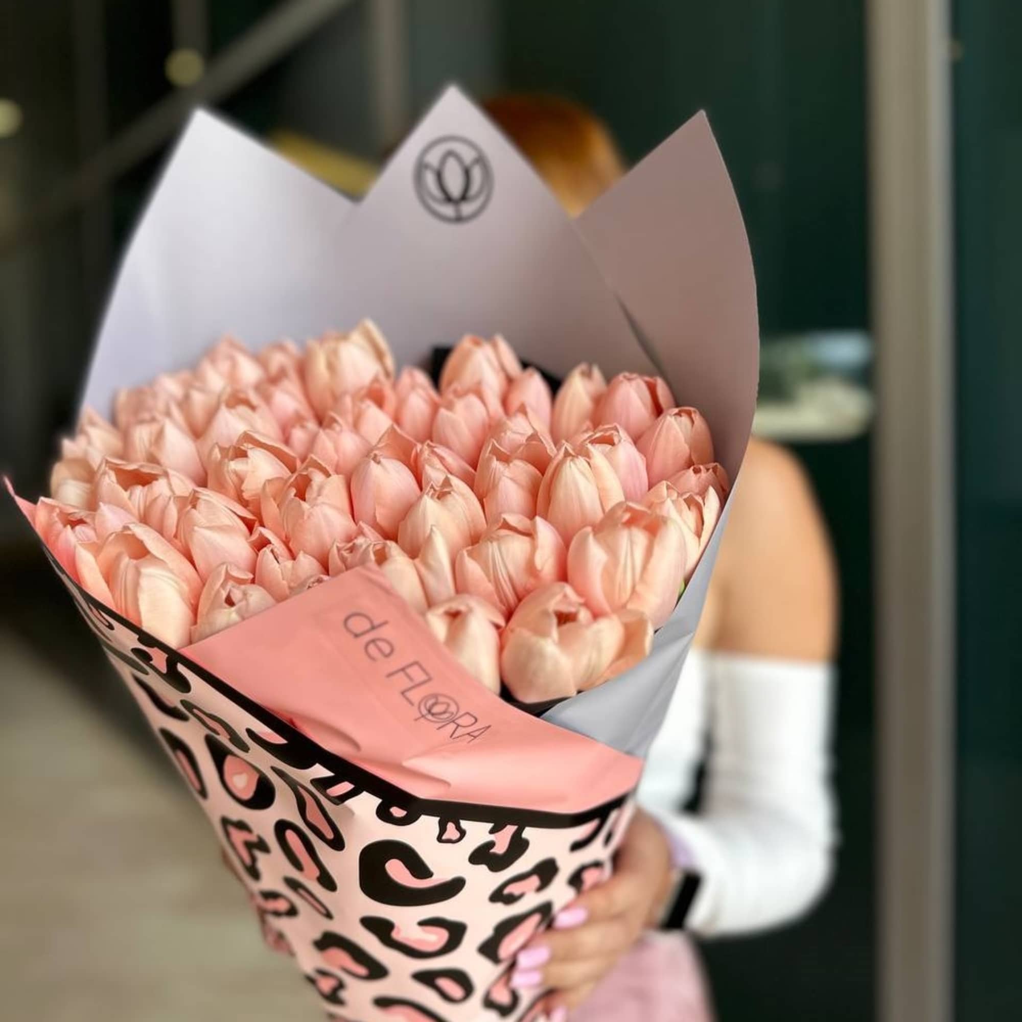 Bouquet of pale pink tulips wrapped in patterned paper