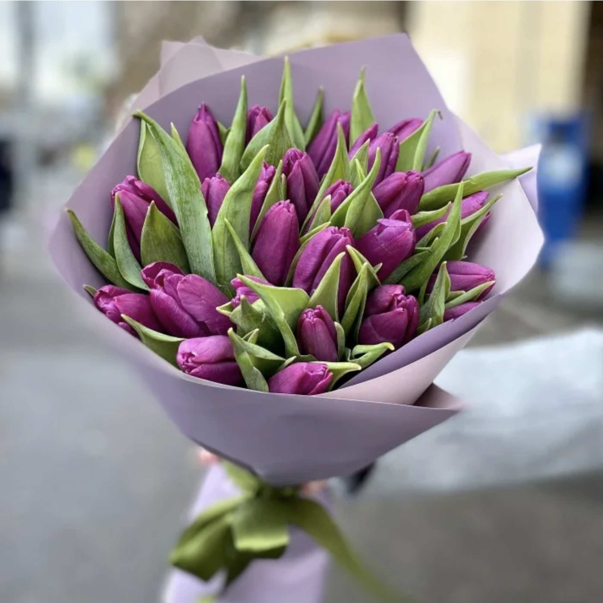 Bouquet of purple tulips wrapped in lavender paper