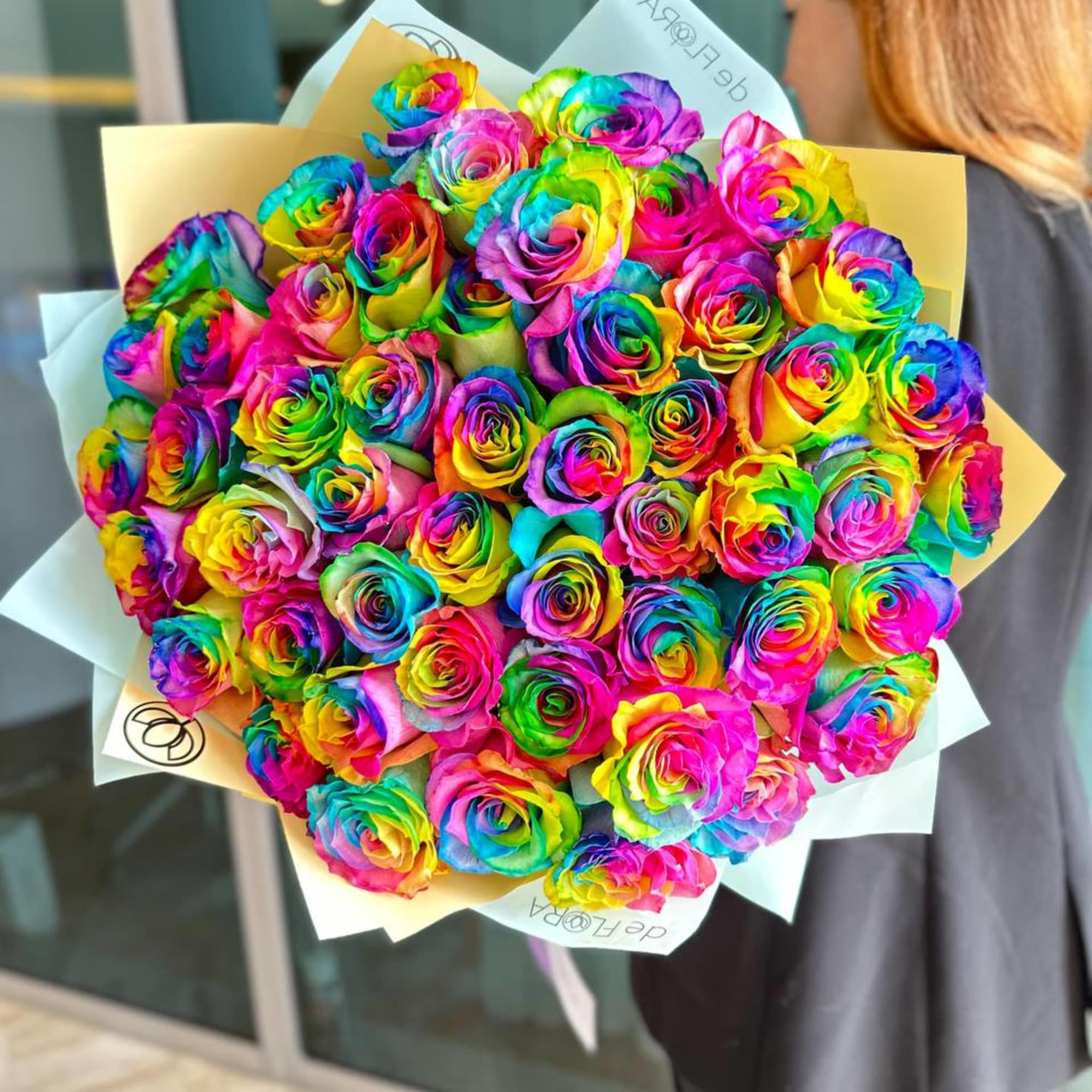 Large bouquet of rainbow-colored roses wrapped in pale paper, photo 5 of 5