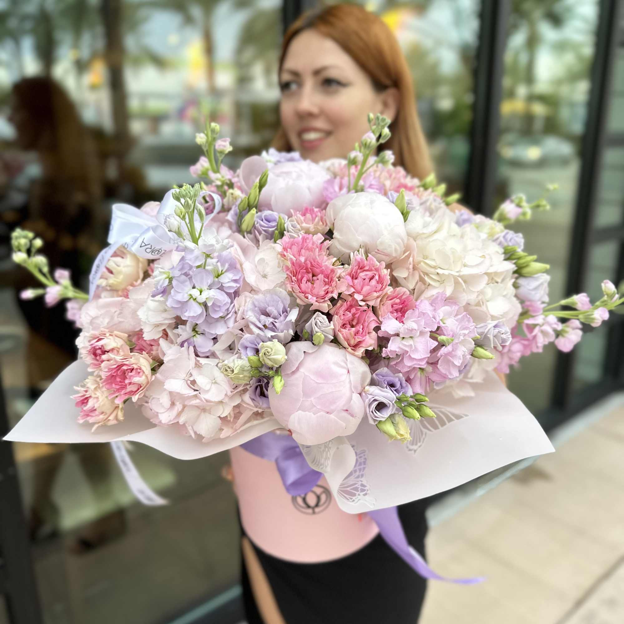 Large pastel bouquet of pink, white, and lavender flowers wrapped in paper