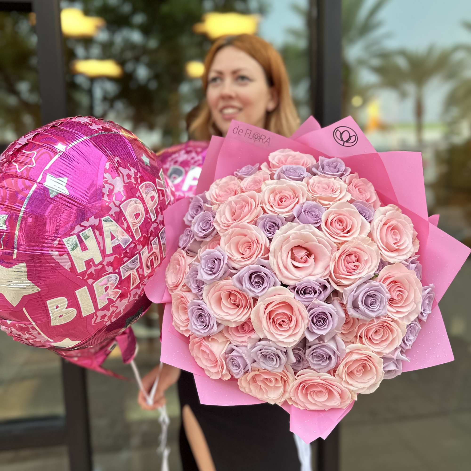 Large bouquet of pink and lavender roses with pink Happy Birthday balloons