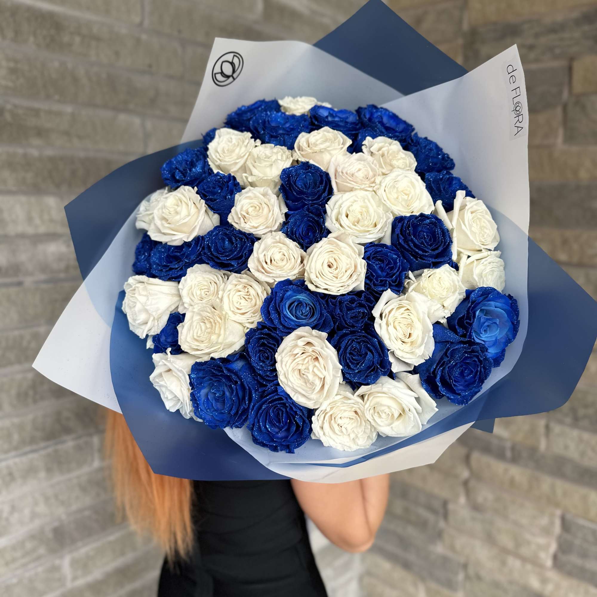 Bouquet of blue and white roses wrapped in blue and white paper