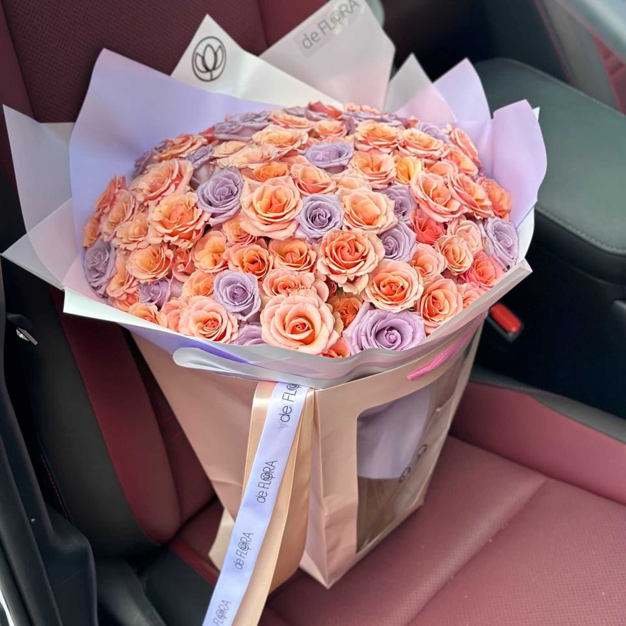 Bouquet of peach and lavender roses wrapped in pastel paper