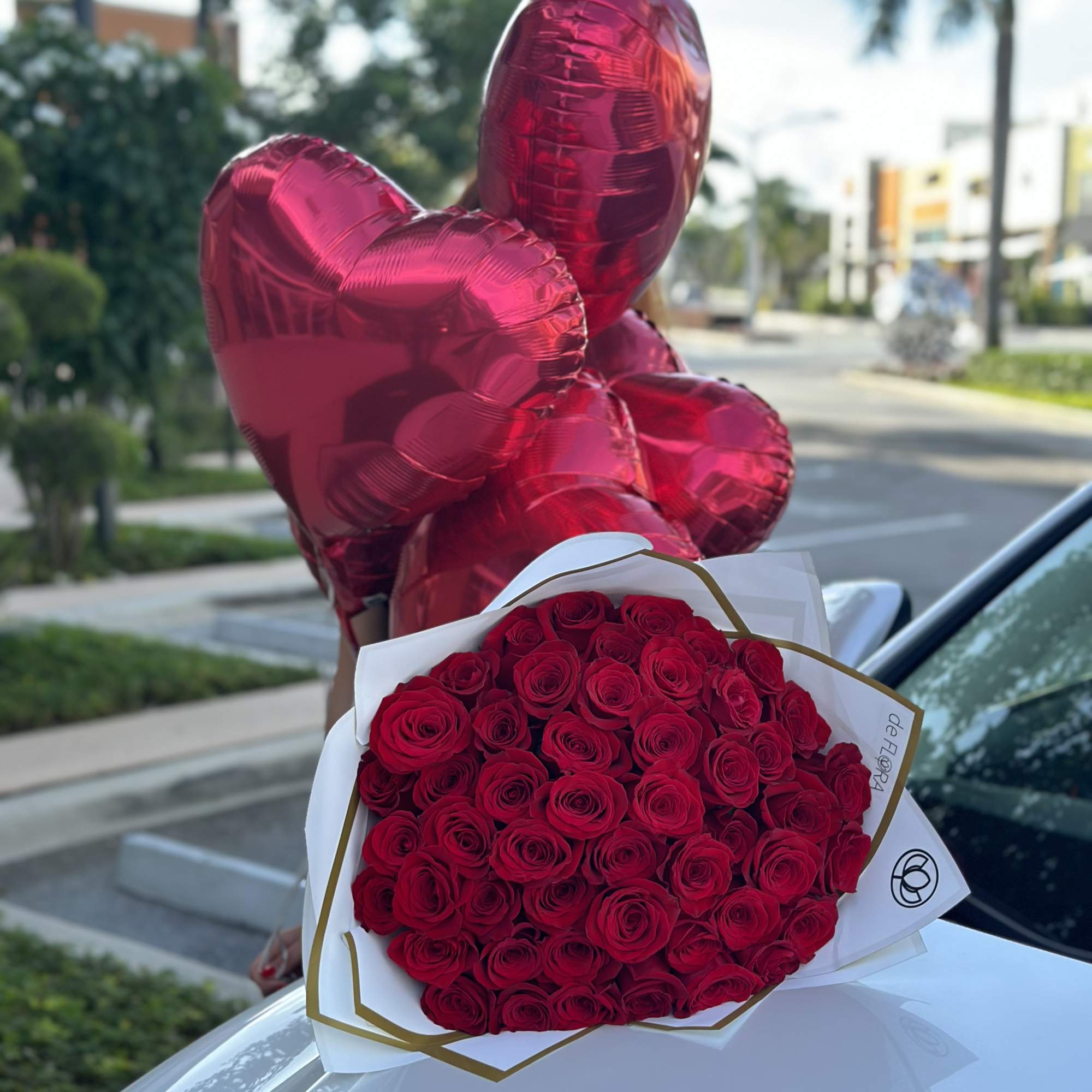 Bouquet of red roses with red heart-shaped balloons