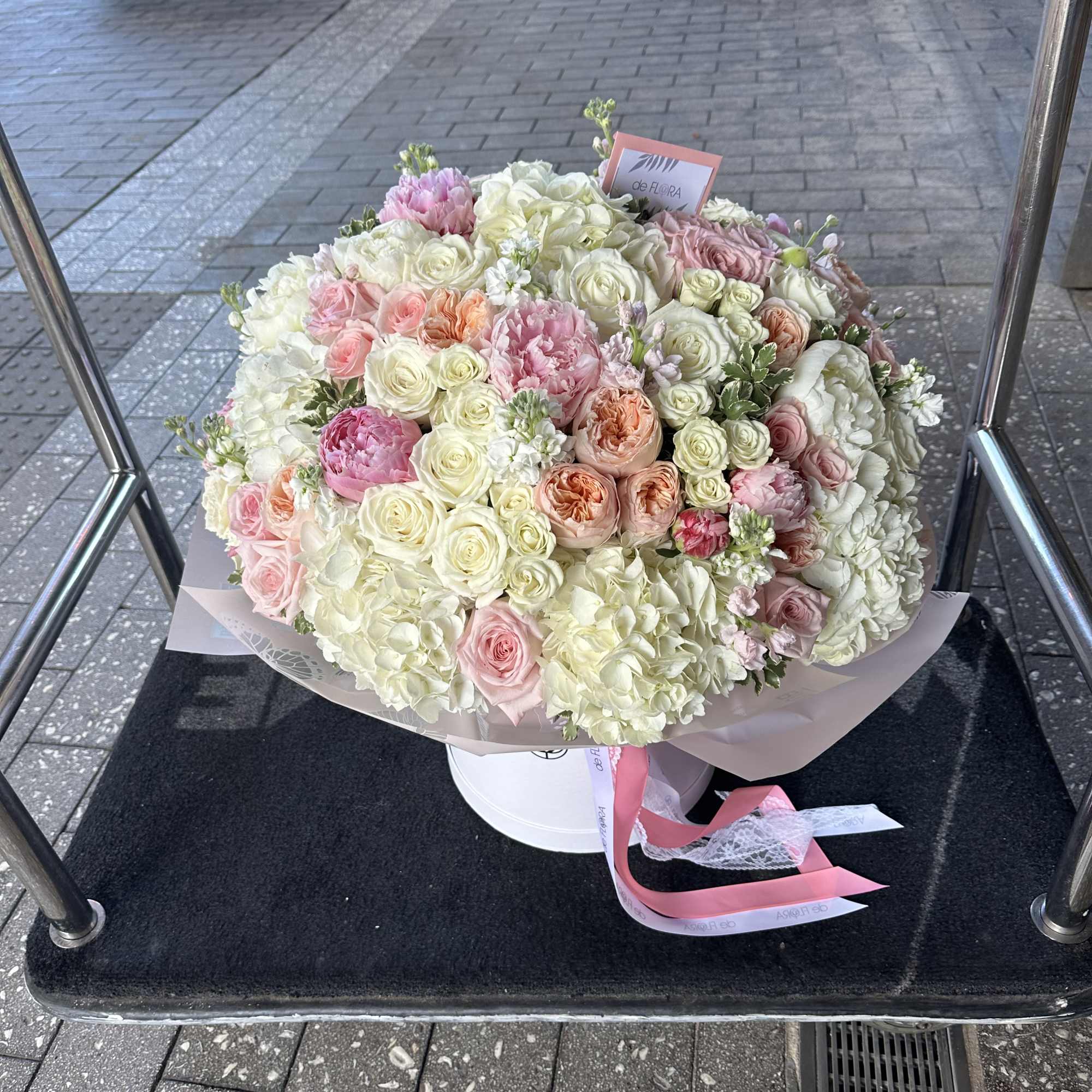 Large bouquet of pale pink and white roses in a white hatbox