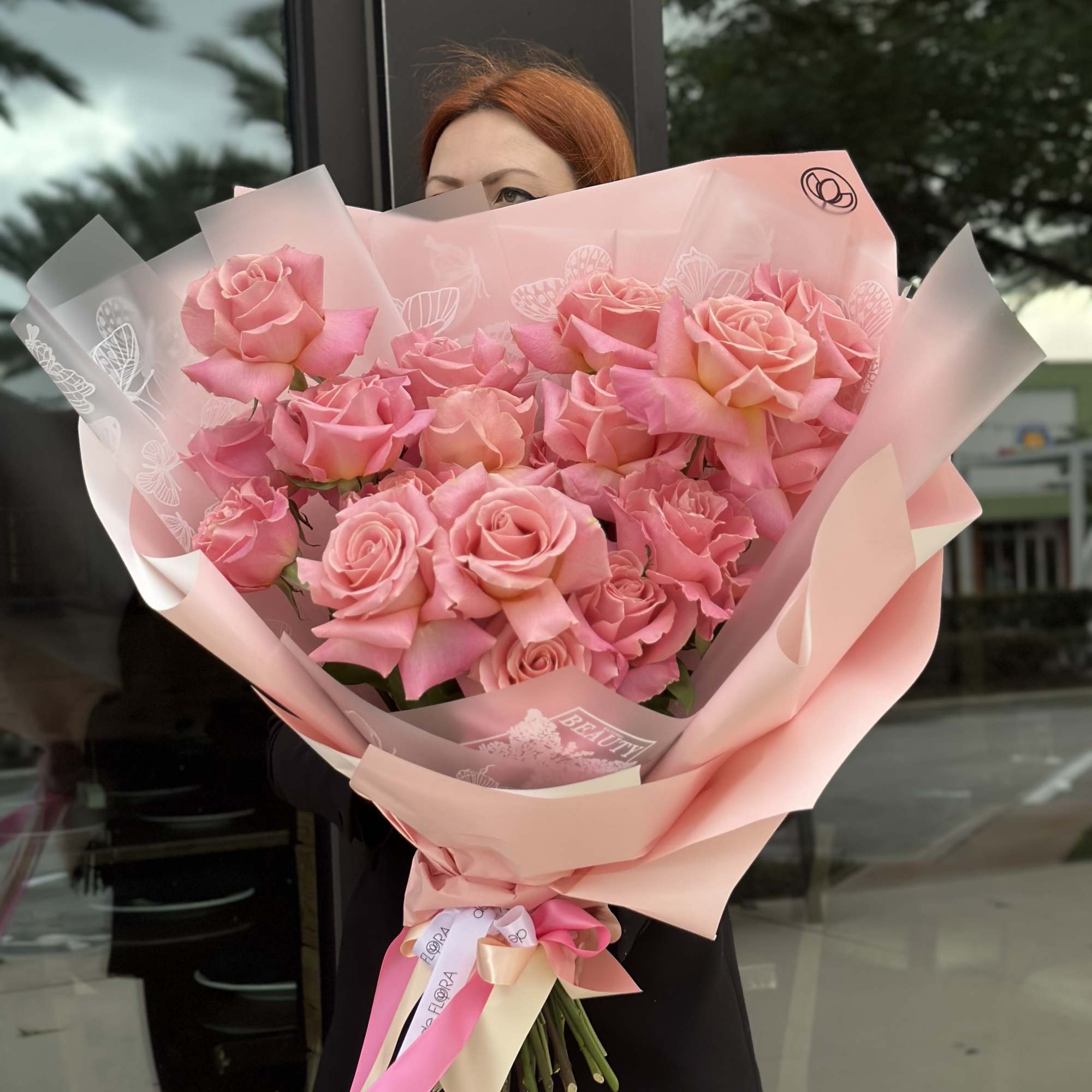 Large bouquet of pink roses wrapped in pale pink paper