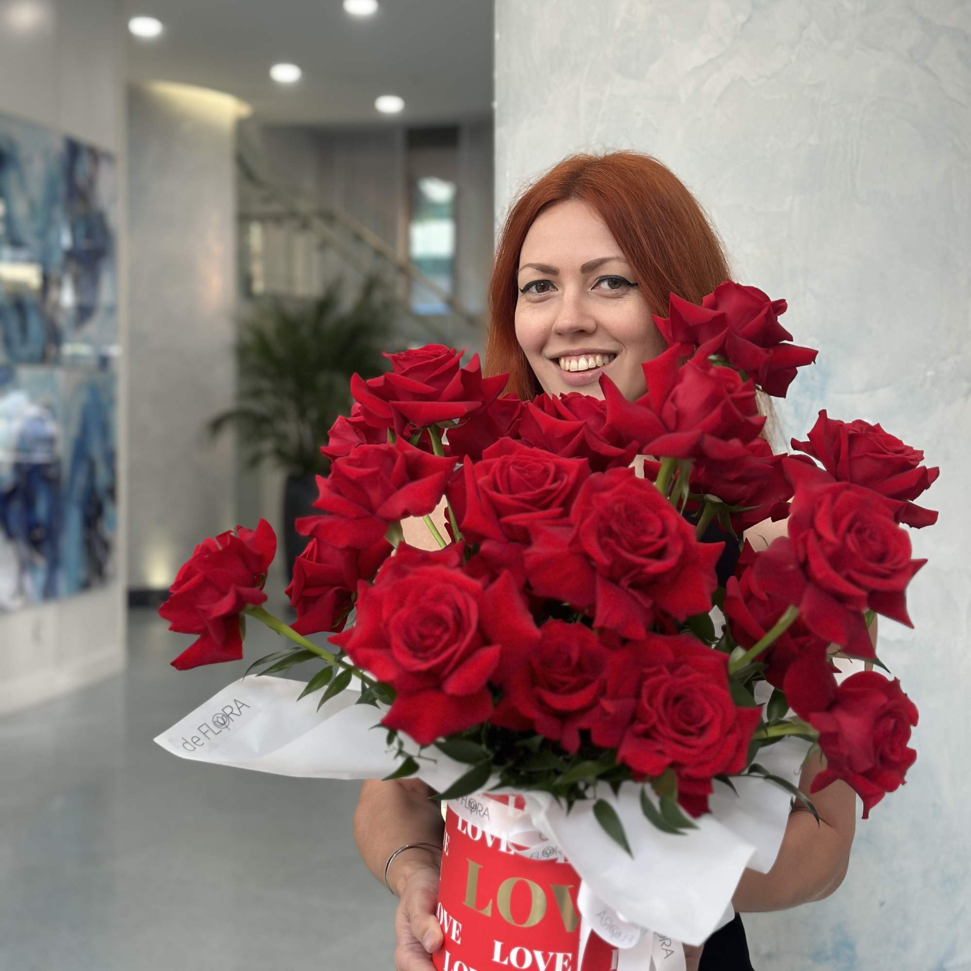 Bouquet of red roses in a red box with white wrapping