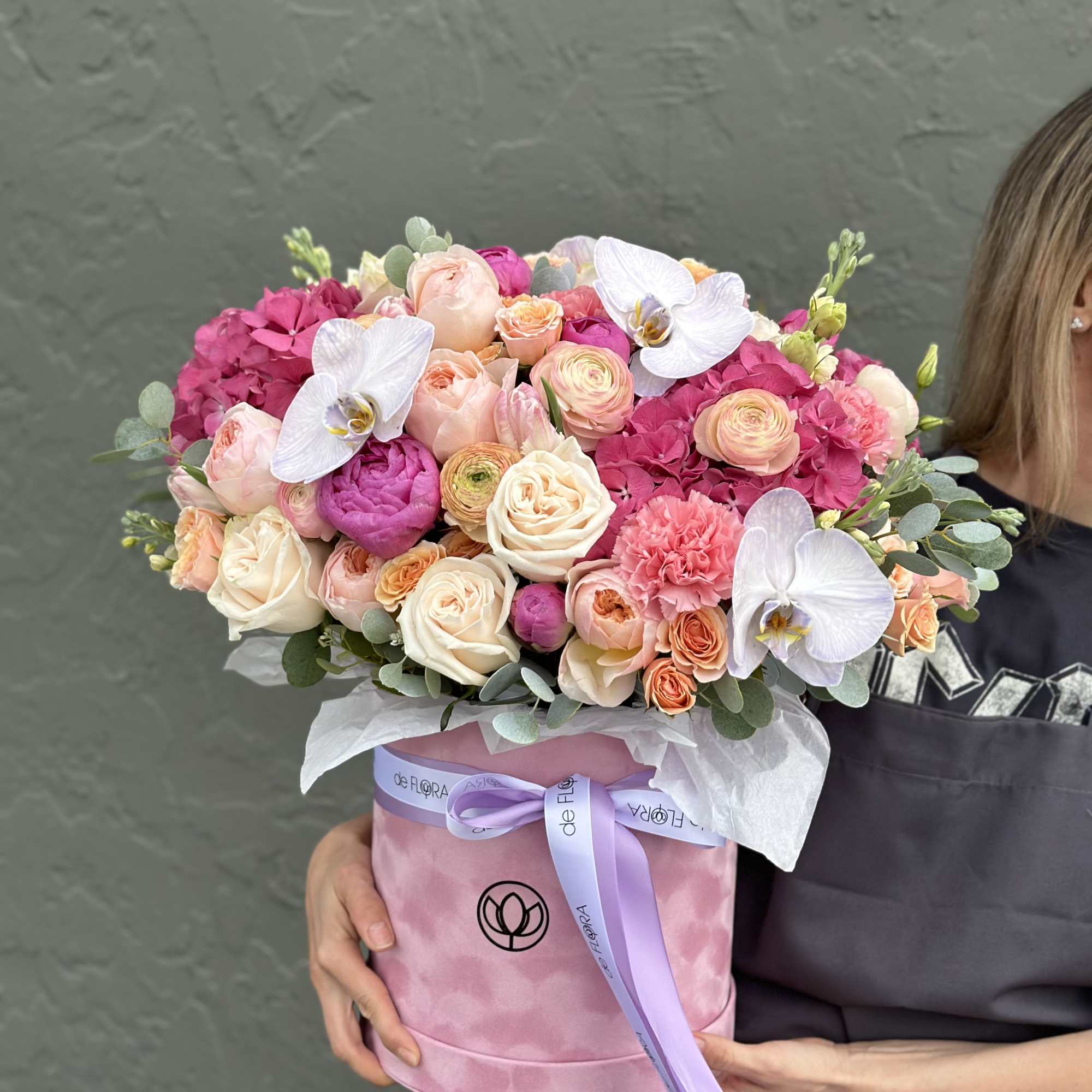 Pink and peach bouquet in a round box with white orchids