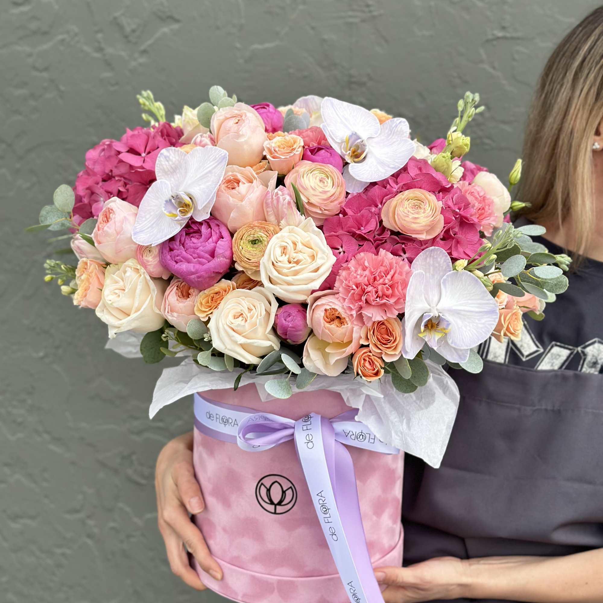 Pink and peach bouquet in a pink hat box with white orchids