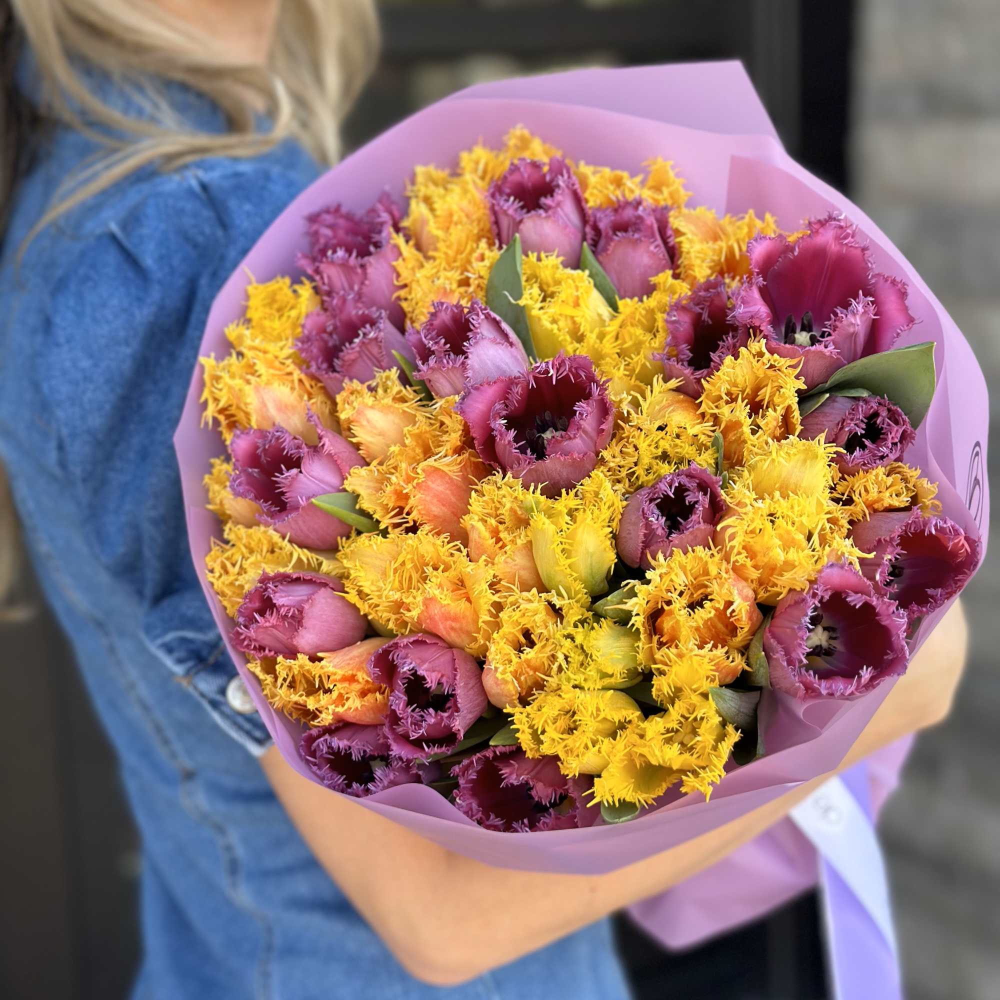Bouquet of purple and yellow fringed tulips wrapped in pink paper