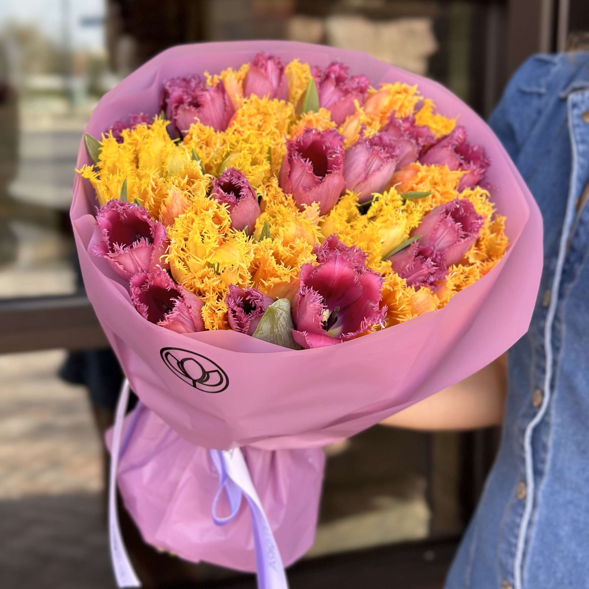 Bouquet of pink and yellow fringed tulips wrapped in pink paper