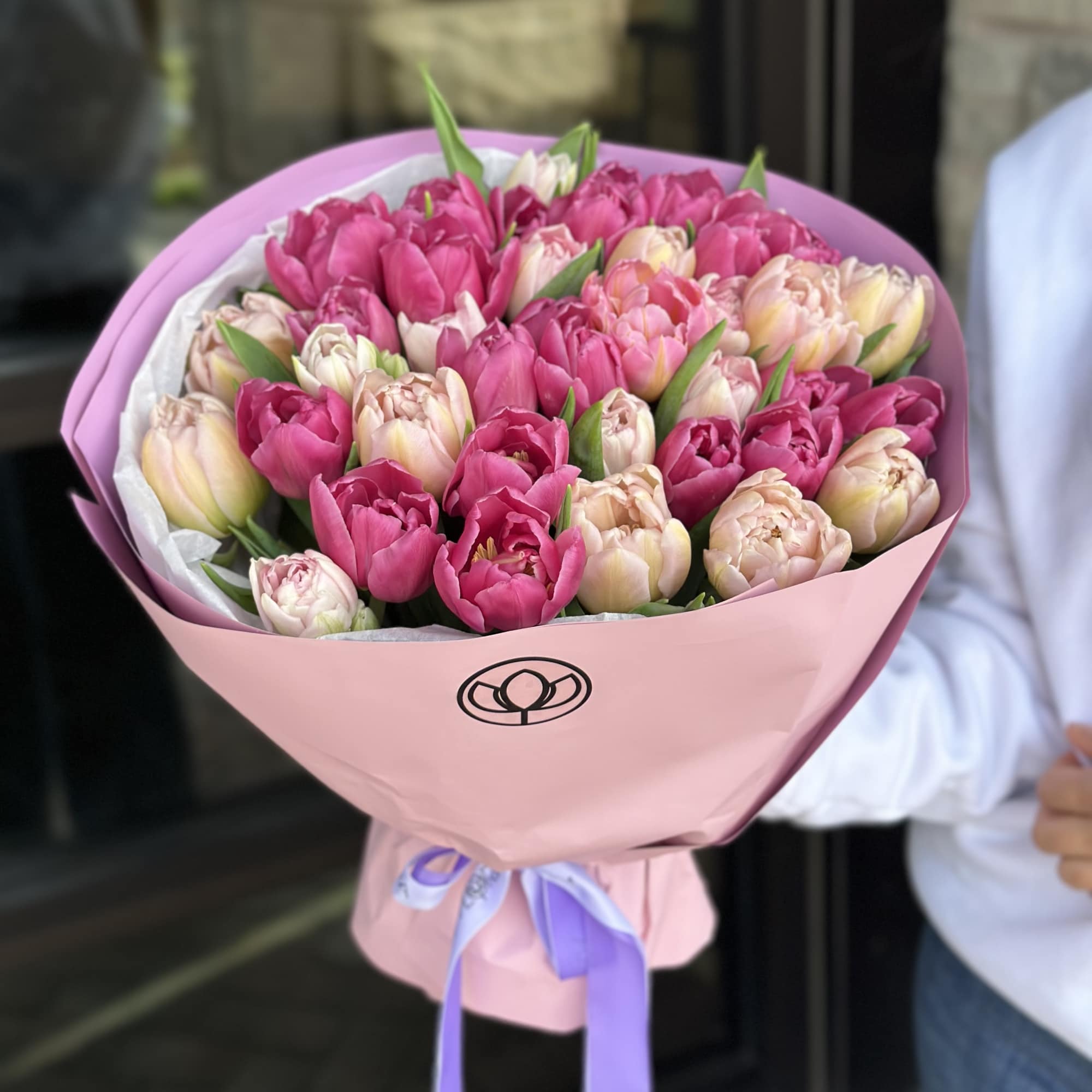 Bouquet of pink and blush tulips wrapped in pink paper