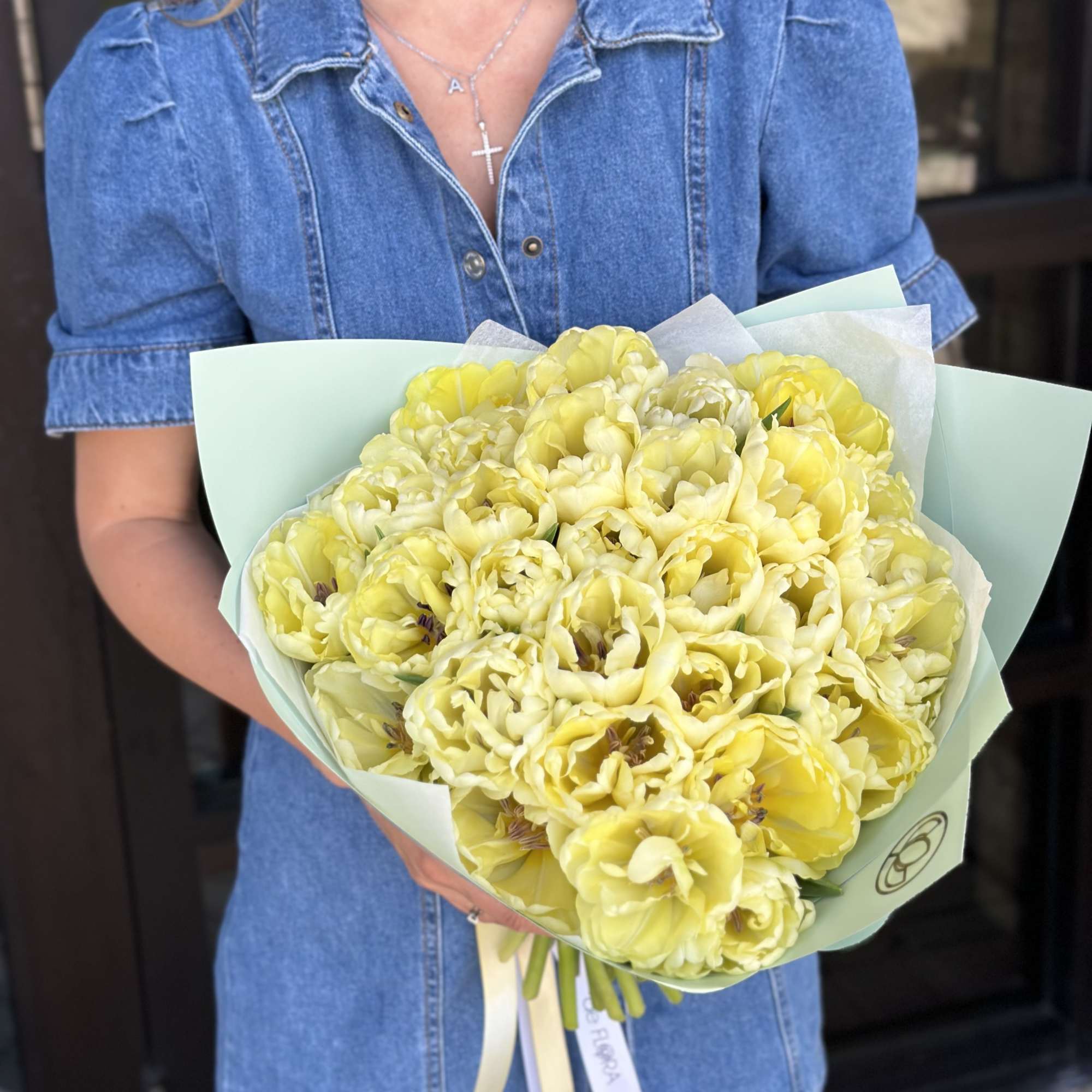 Bouquet of pale yellow tulips wrapped in light paper