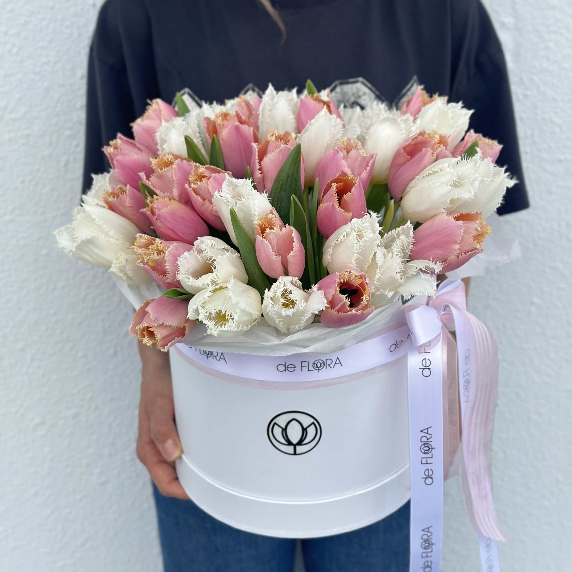 Pink and white fringed tulips in a white hatbox with ribbon
