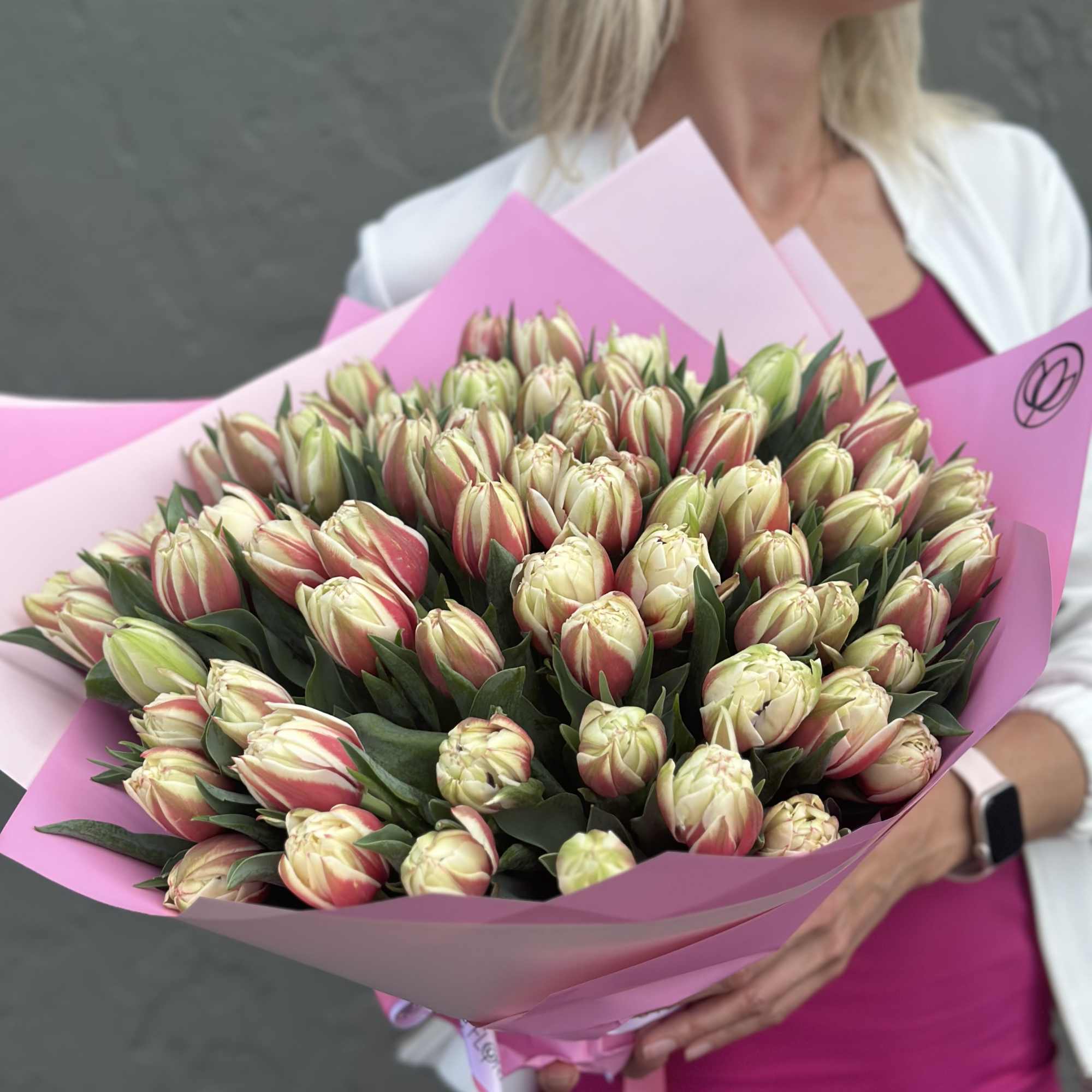 Large bouquet of pink and cream tulips wrapped in pink paper