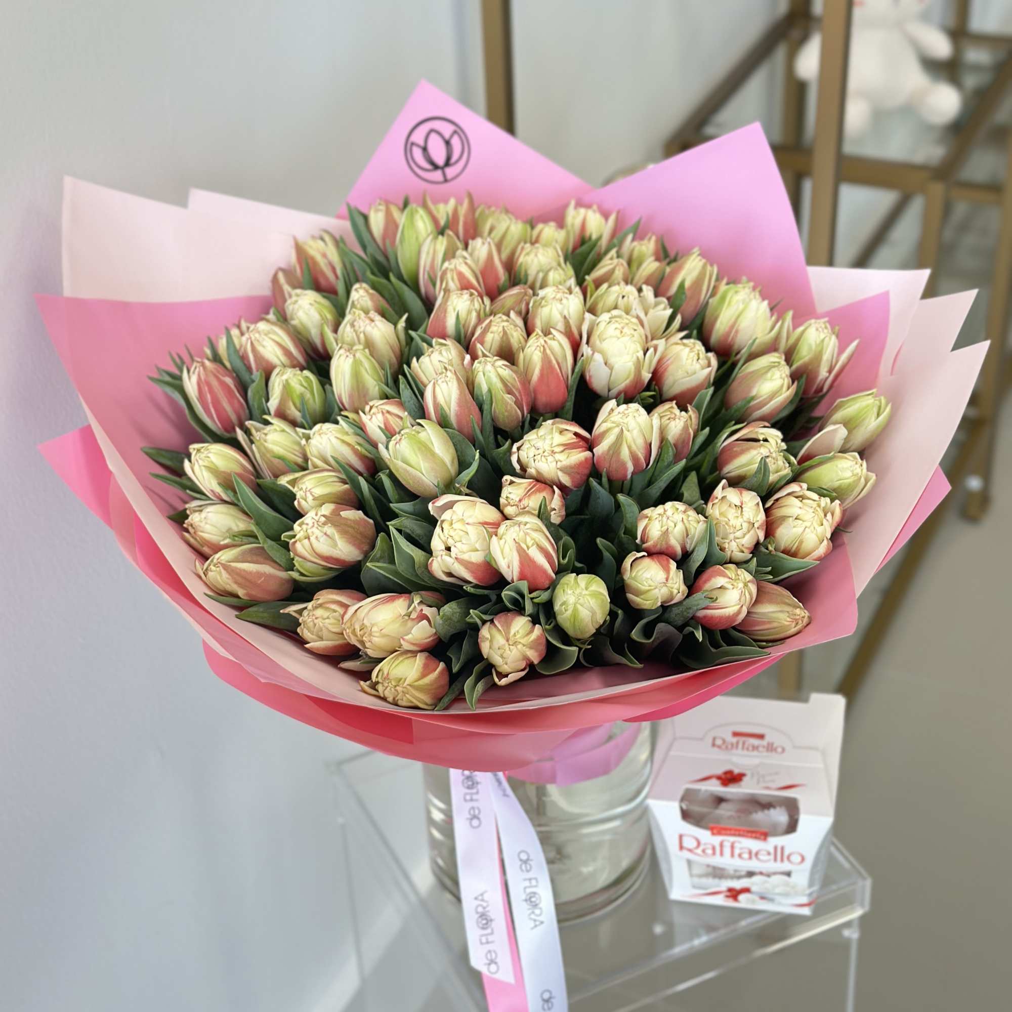 Bouquet of pale pink and cream tulips wrapped in pink paper