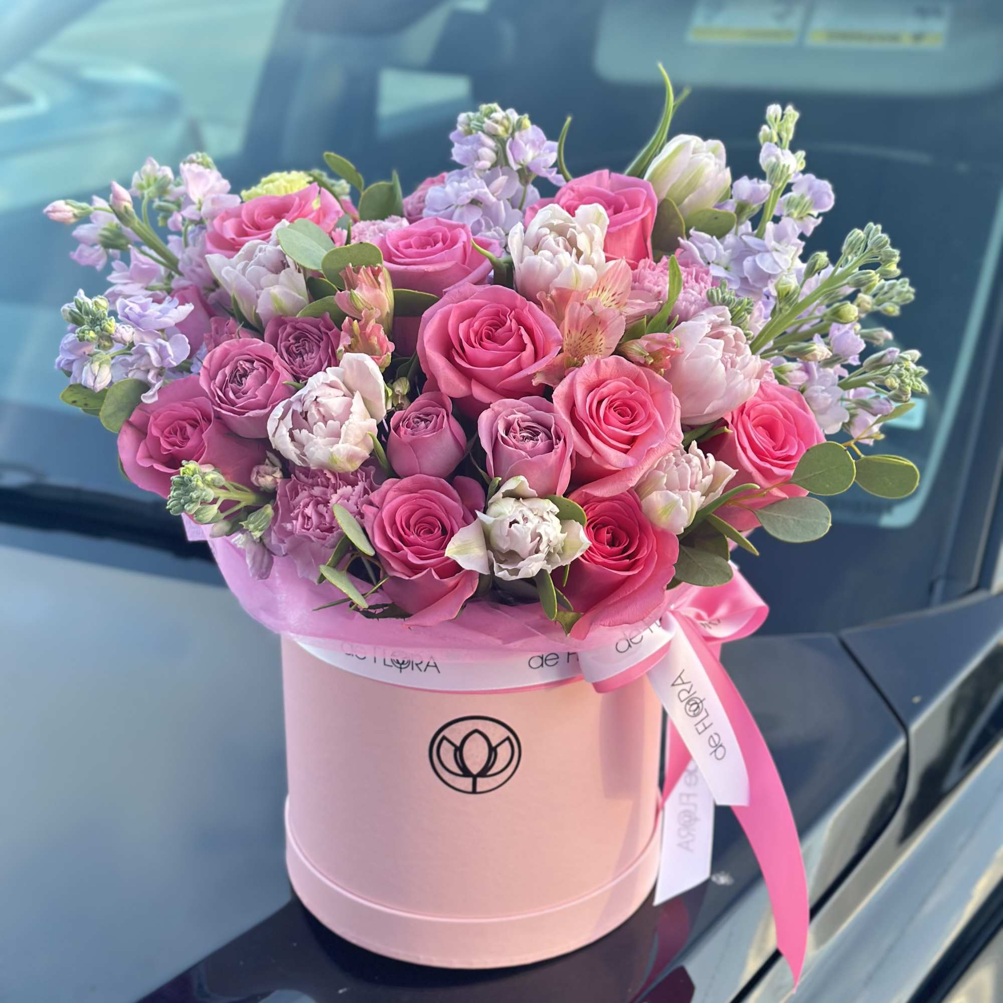 Pink and lavender rose bouquet in a round pink box with ribbon
