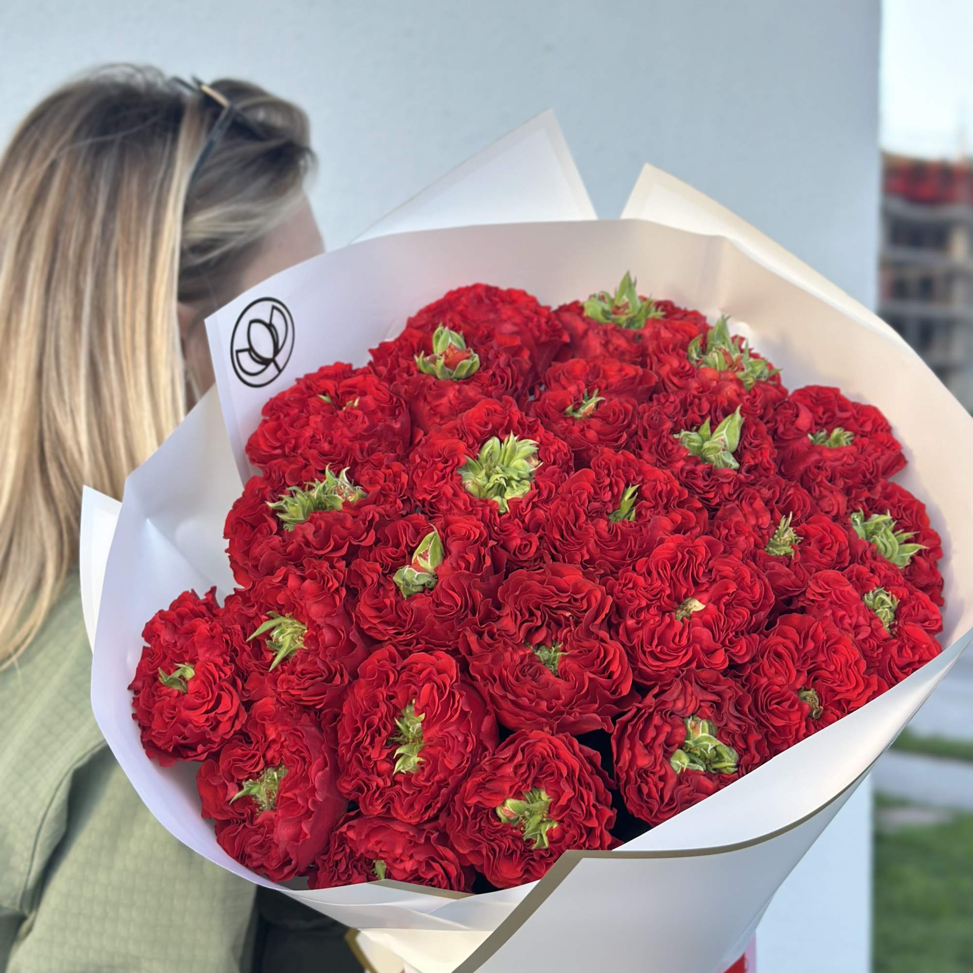Large bouquet of red roses wrapped in white paper