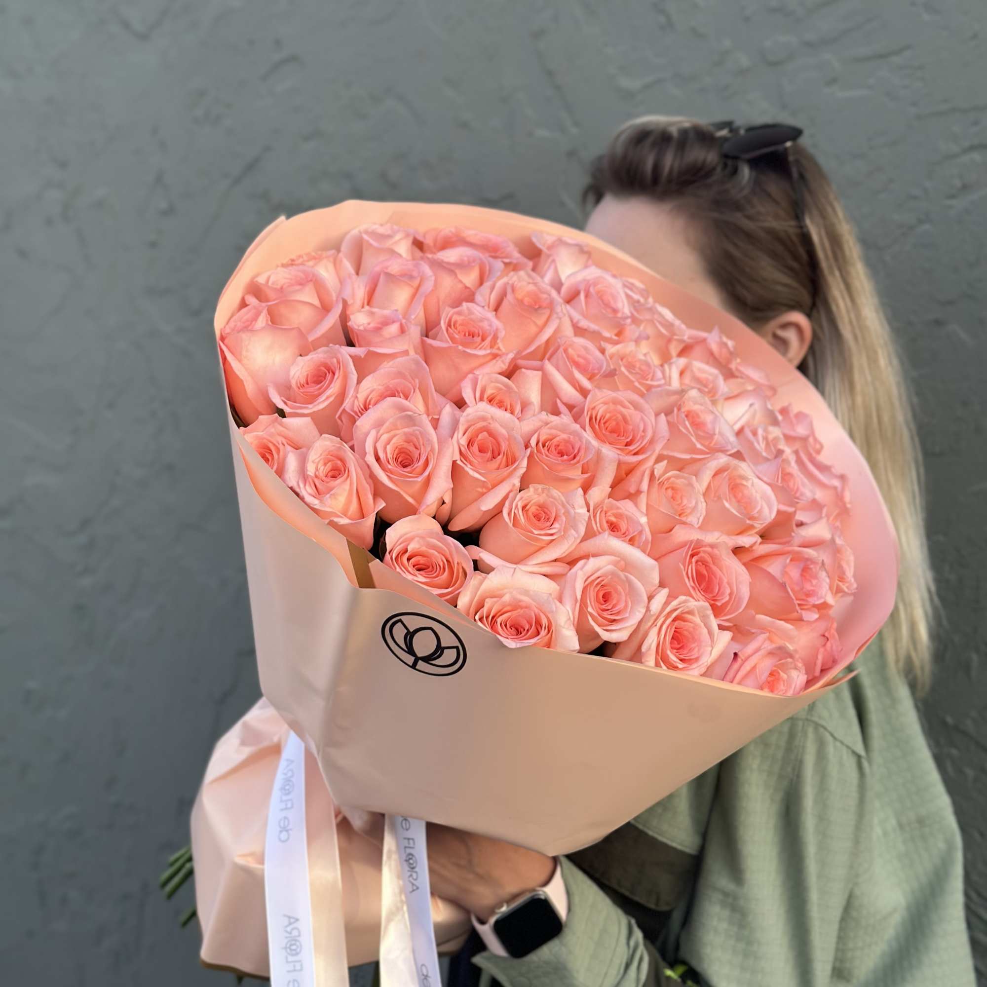 Large bouquet of peach-pink roses wrapped in blush paper