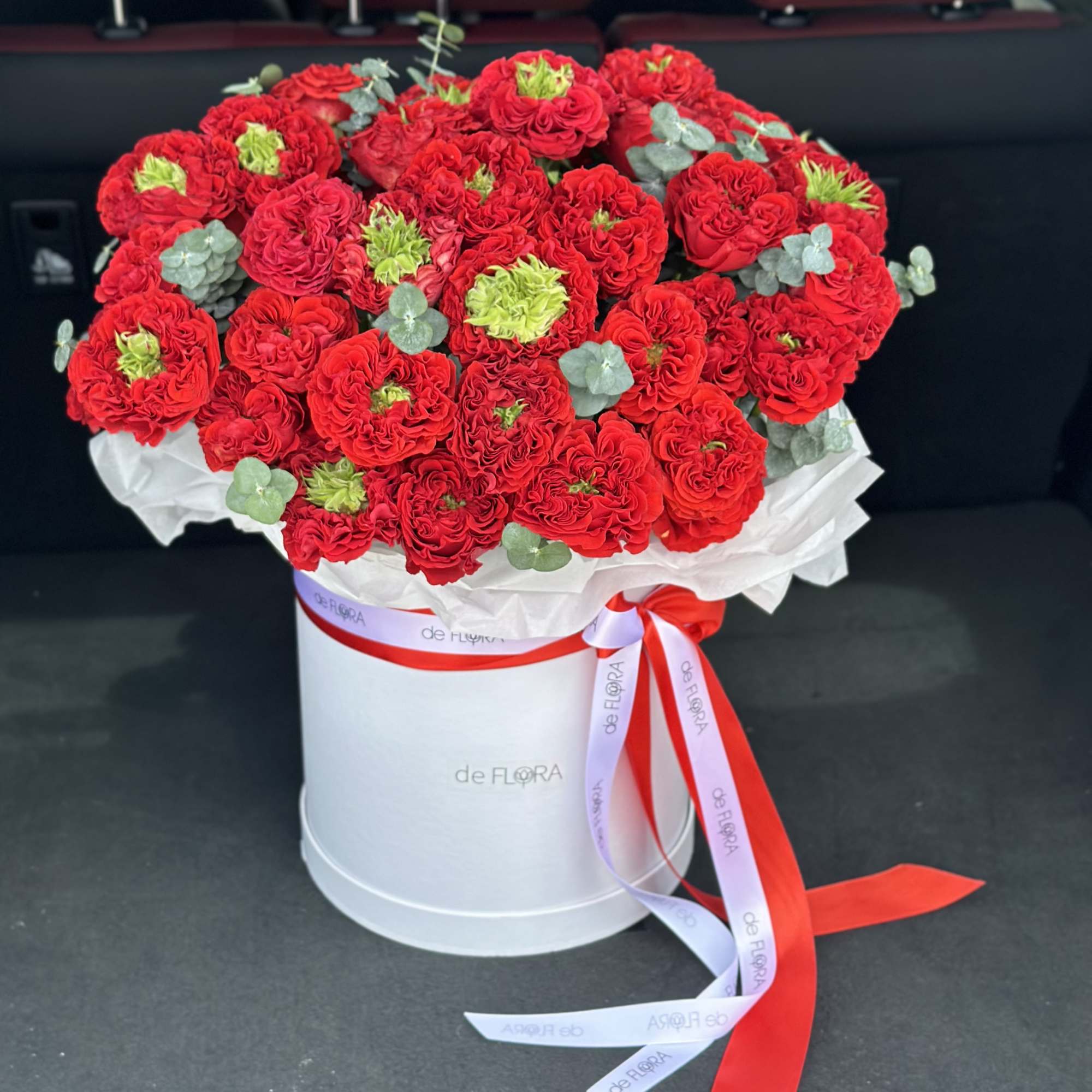 Red rose bouquet in a white hatbox with ribbon