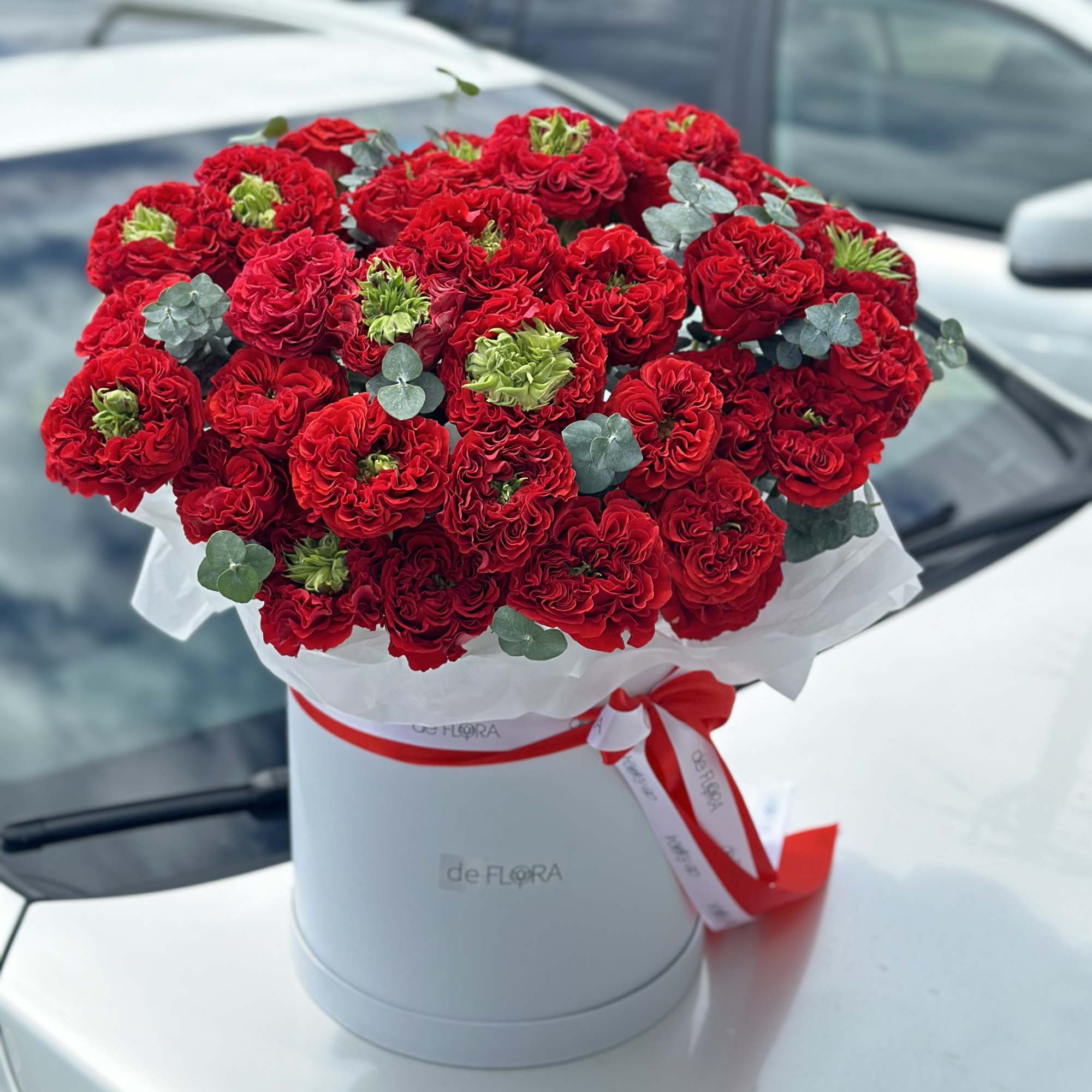 Red rose bouquet in a white hat box with a red ribbon