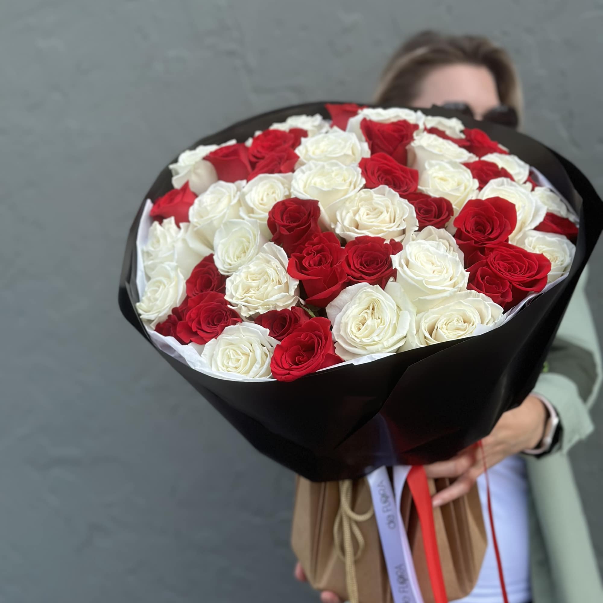 Large bouquet of red and white roses wrapped in black paper