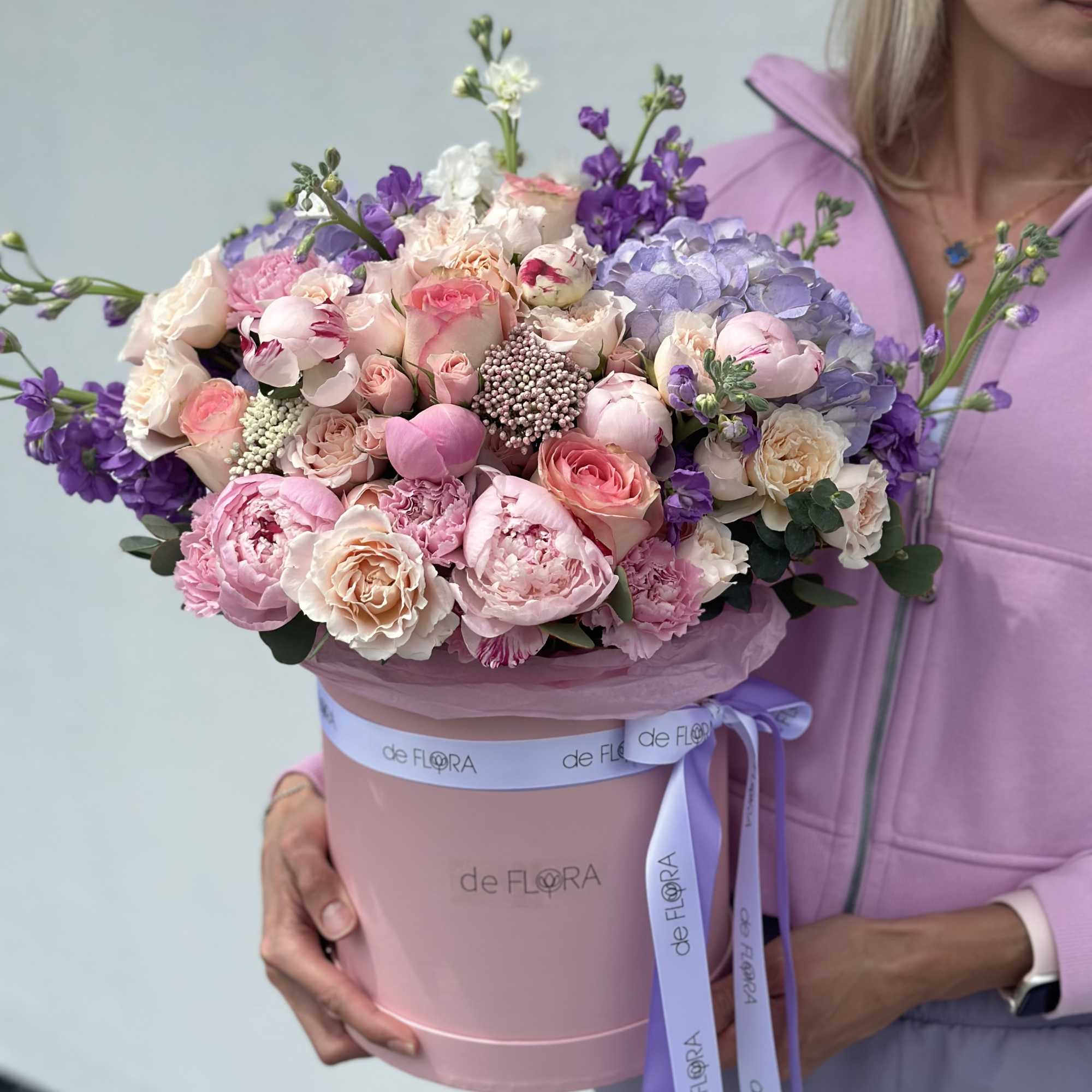 Large pastel bouquet in a pink hatbox with a lavender ribbon