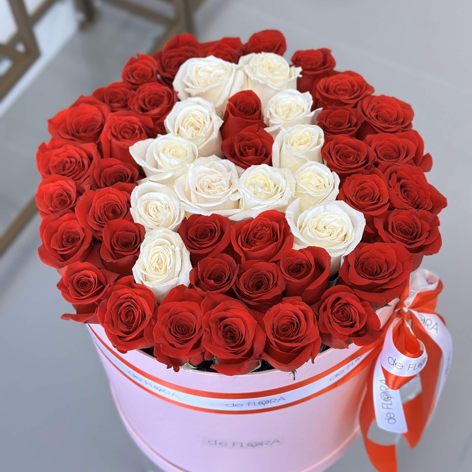 Round box of red and white roses tied with a ribbon