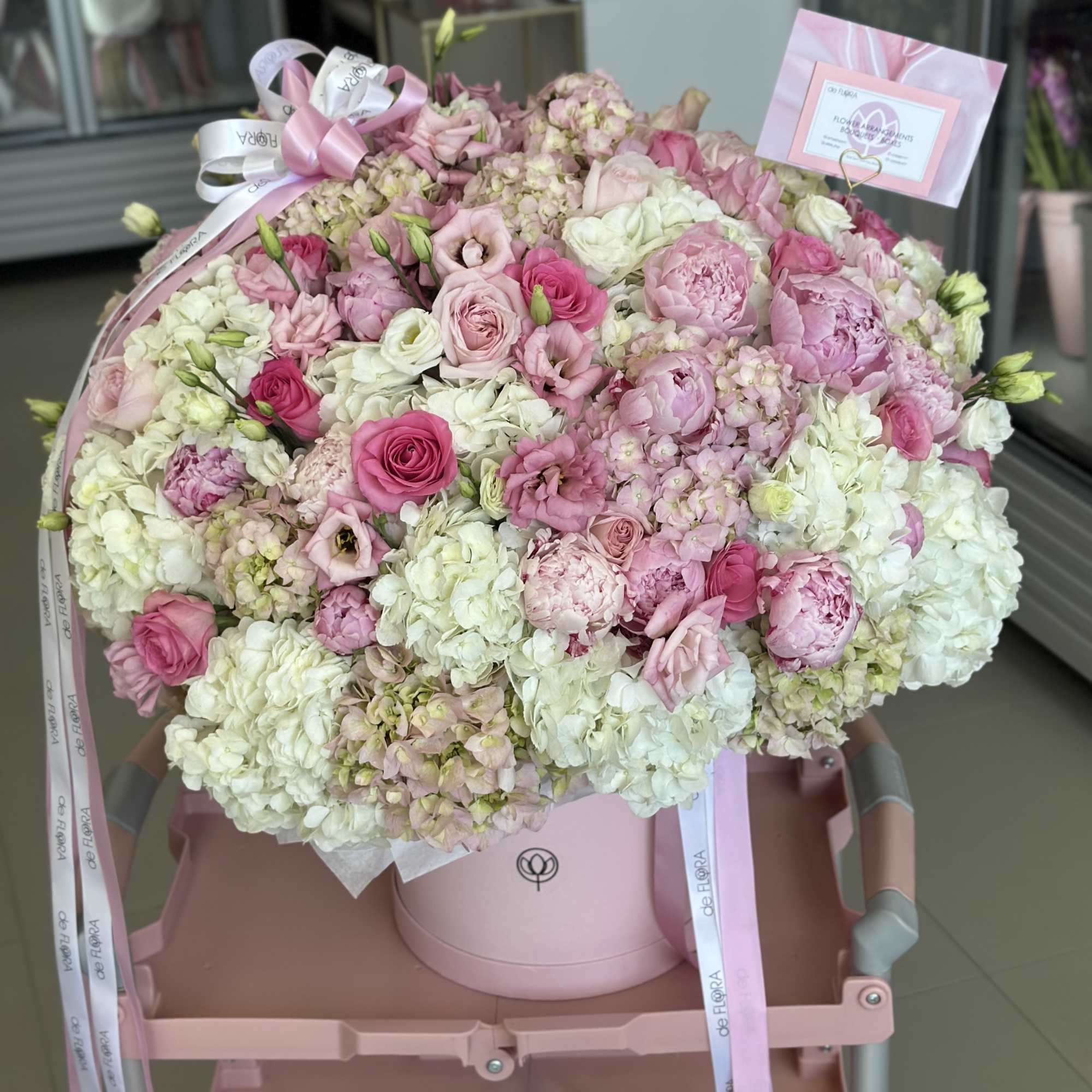 Large pink and white bouquet in a round hatbox with ribbon
