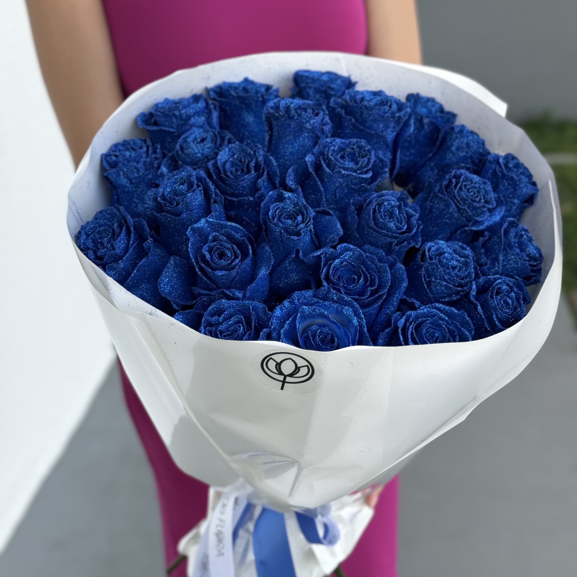 Bouquet of blue roses wrapped in white paper