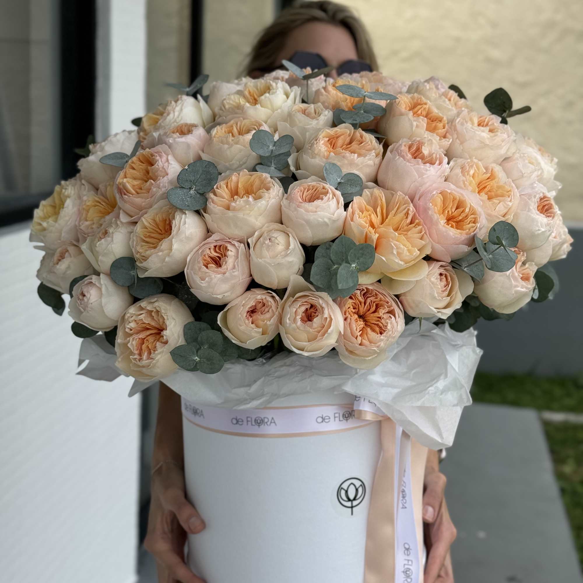Large bouquet of blush and peach roses in a white hat box