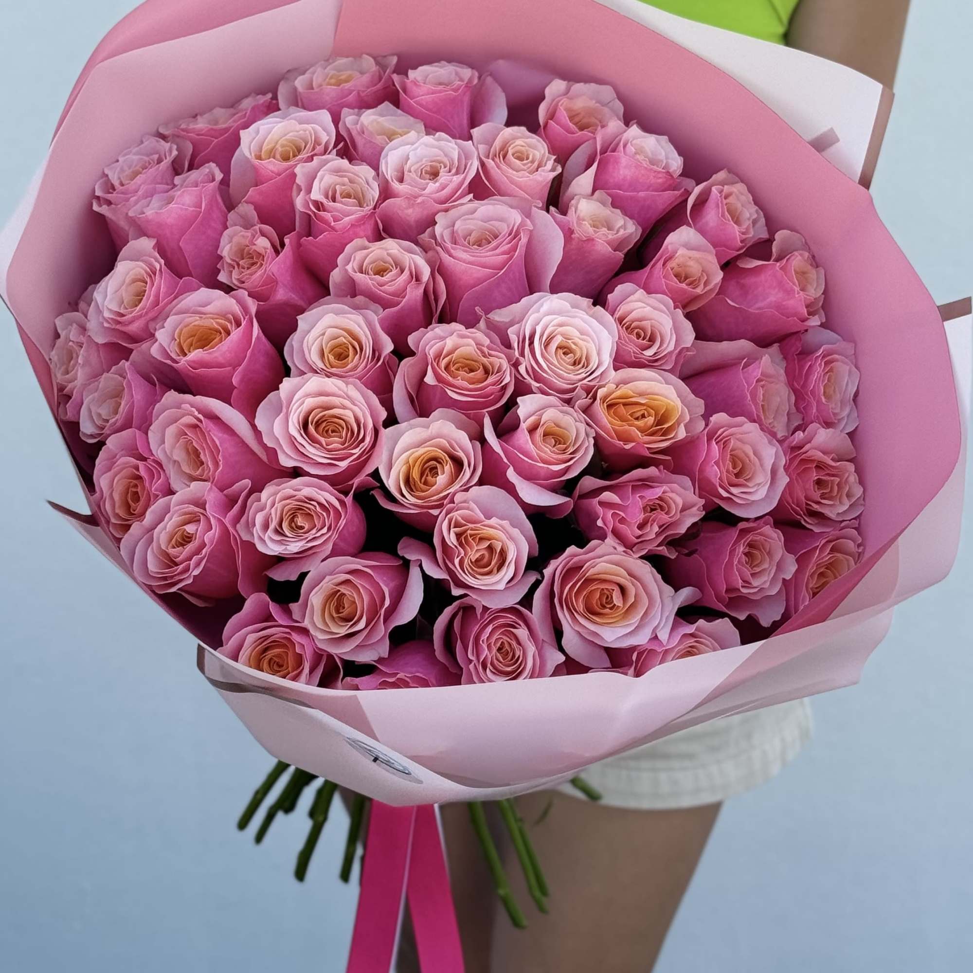 Large bouquet of pink roses wrapped in pink paper