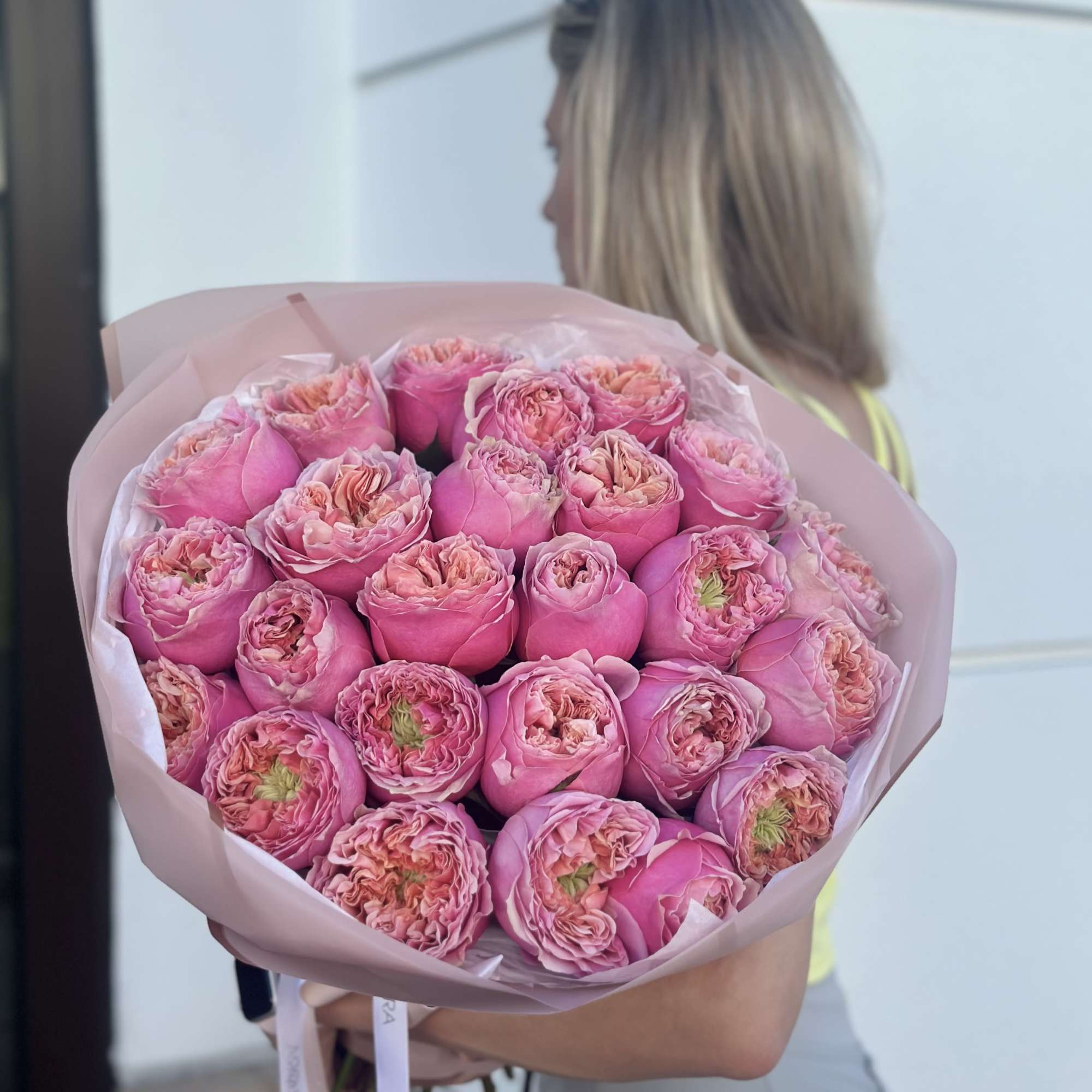 Large bouquet of pink roses wrapped in pale pink paper