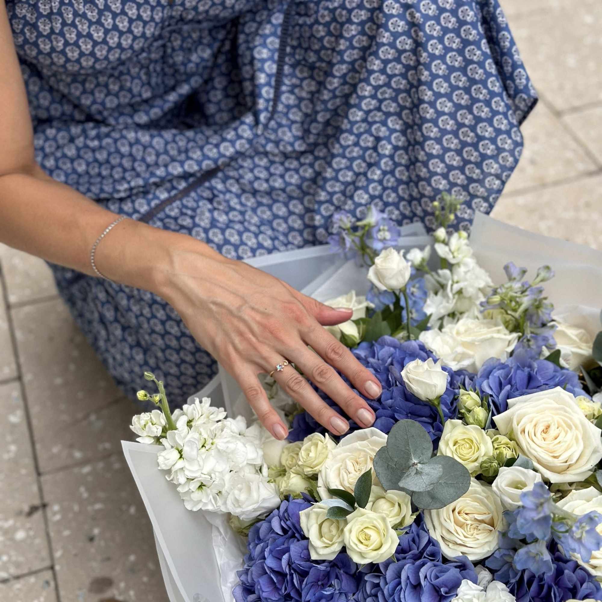 Woman holding a bouquet of blue hydrangeas and white roses