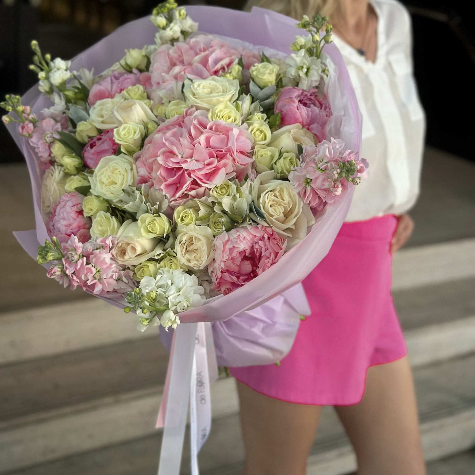 Large pink and cream bouquet wrapped in lavender paper