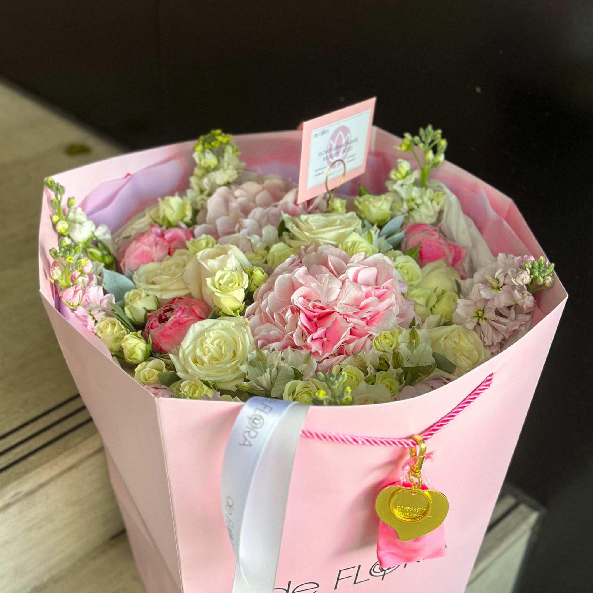 Pink bouquet with pale roses and hydrangea in a pink wrap