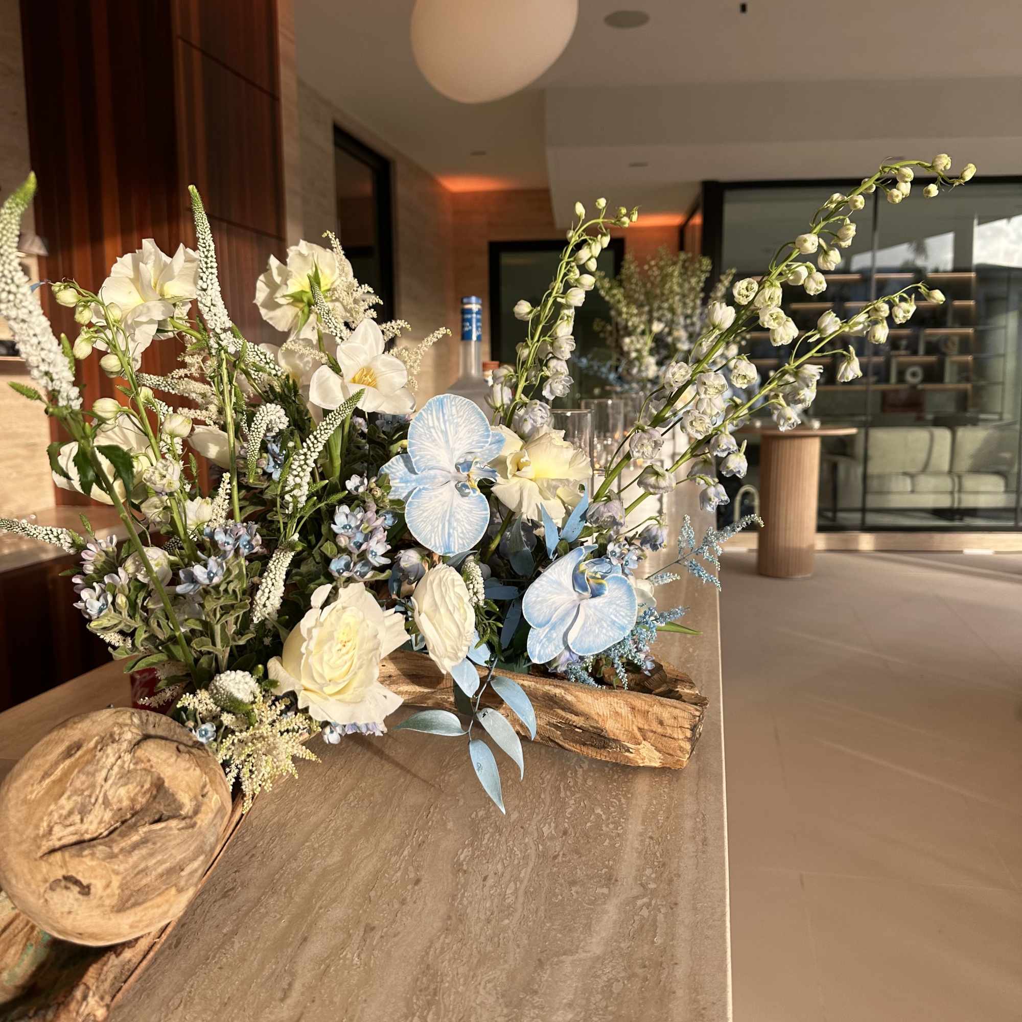 Floral arrangement with white and pale blue flowers in a rustic wood base