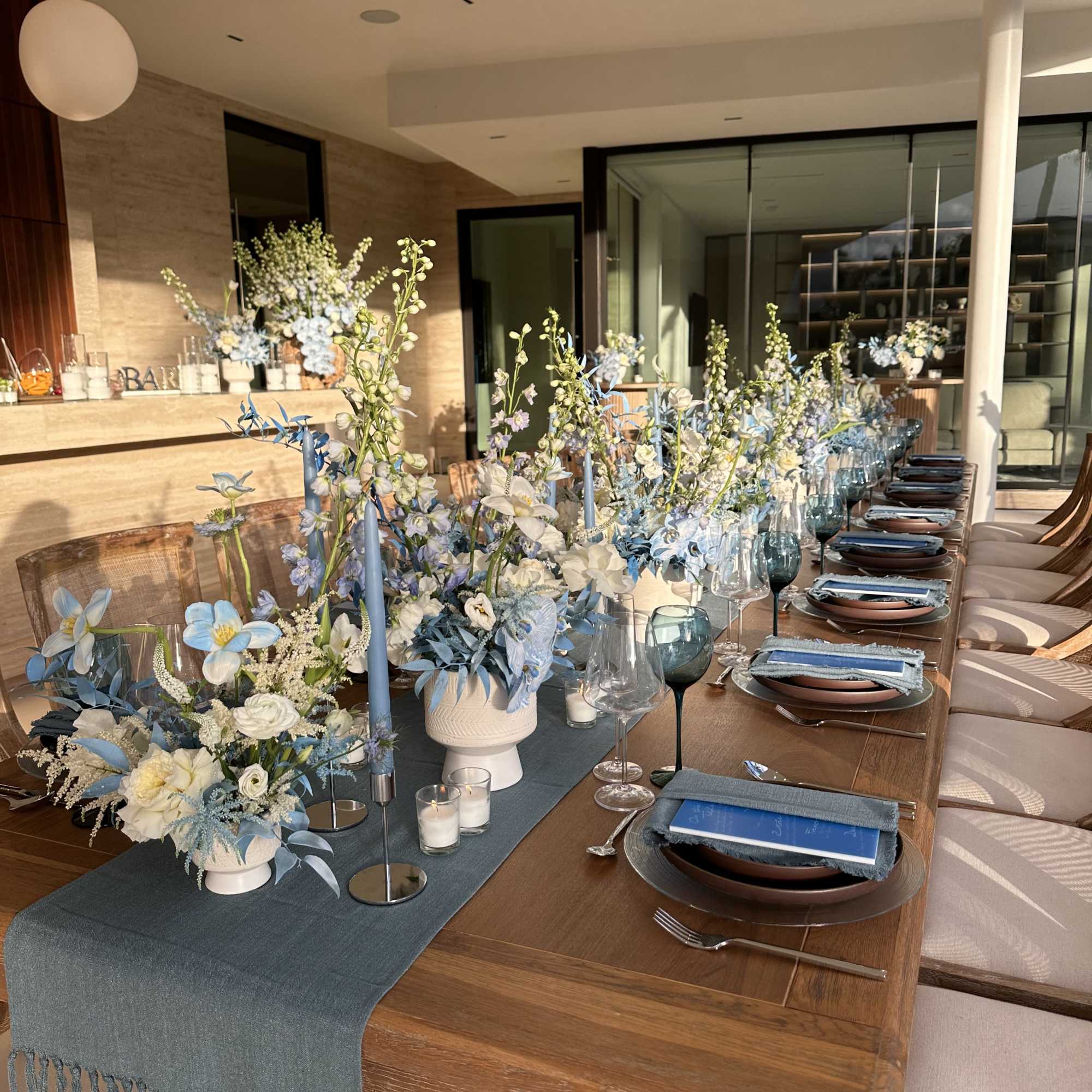 Long dining table with blue-and-white floral centerpieces and place settings