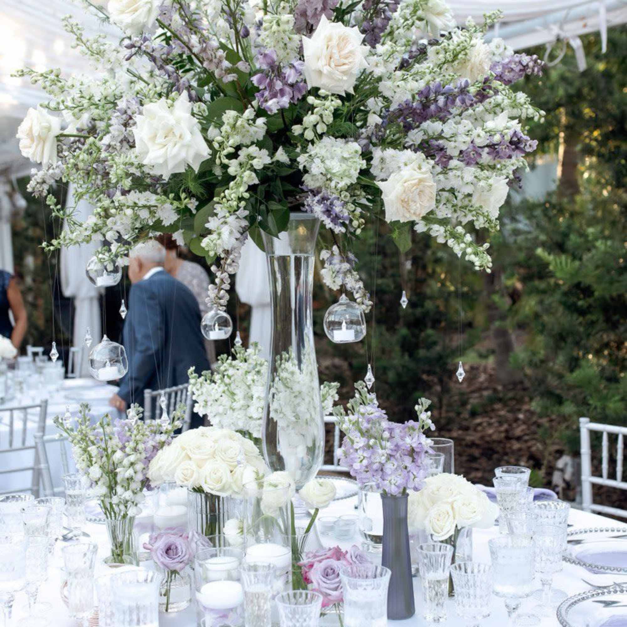 Tall white and lavender floral centerpiece on a wedding table