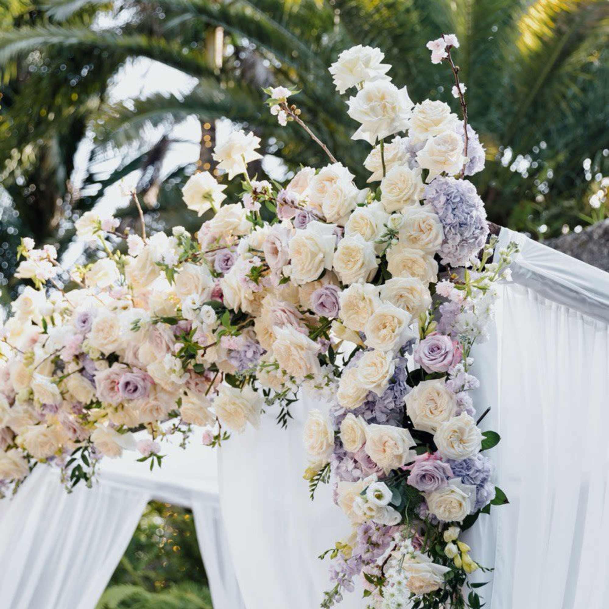Large white and blush floral wedding arch with cascading roses
