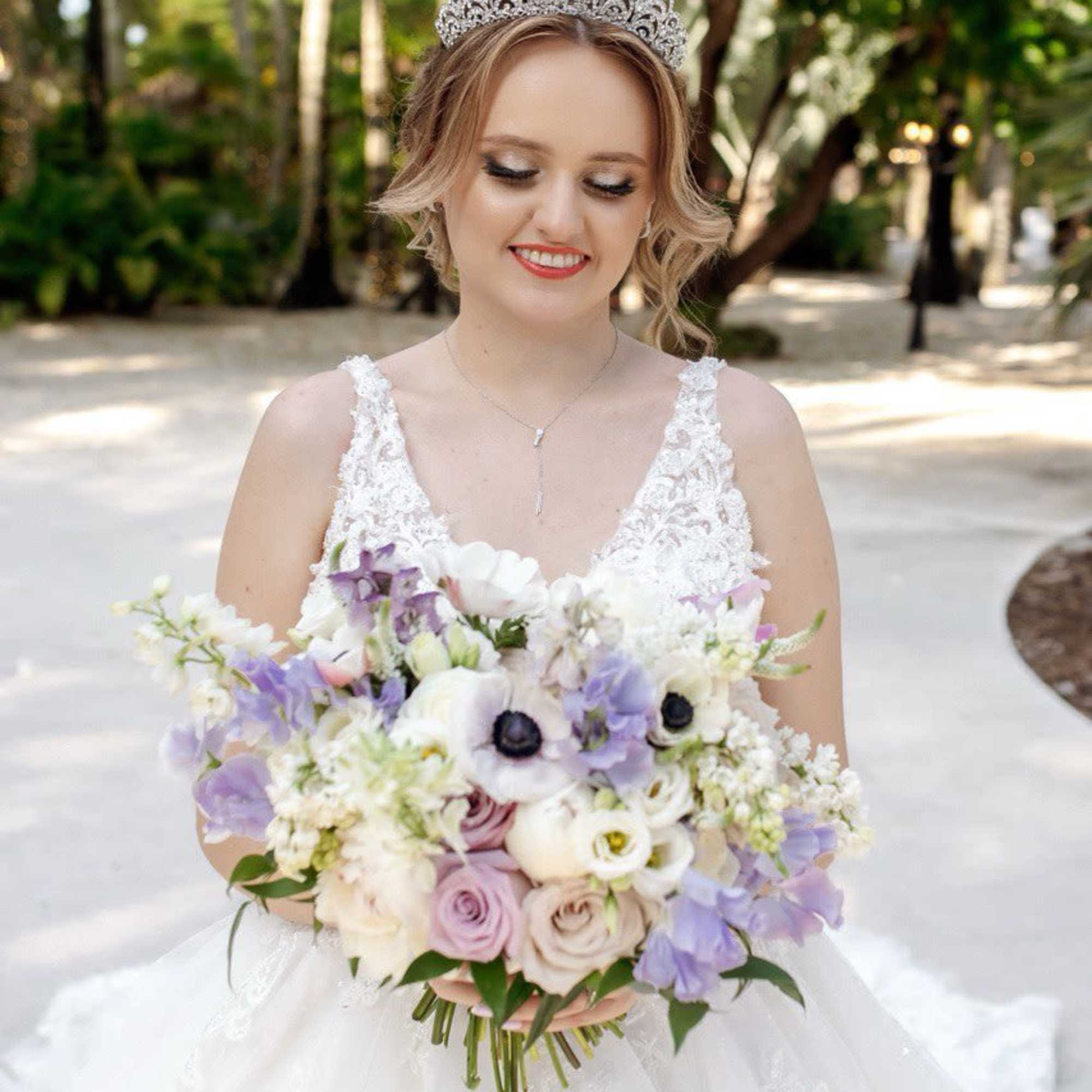 Bride holding a pastel bouquet with white and lavender flowers