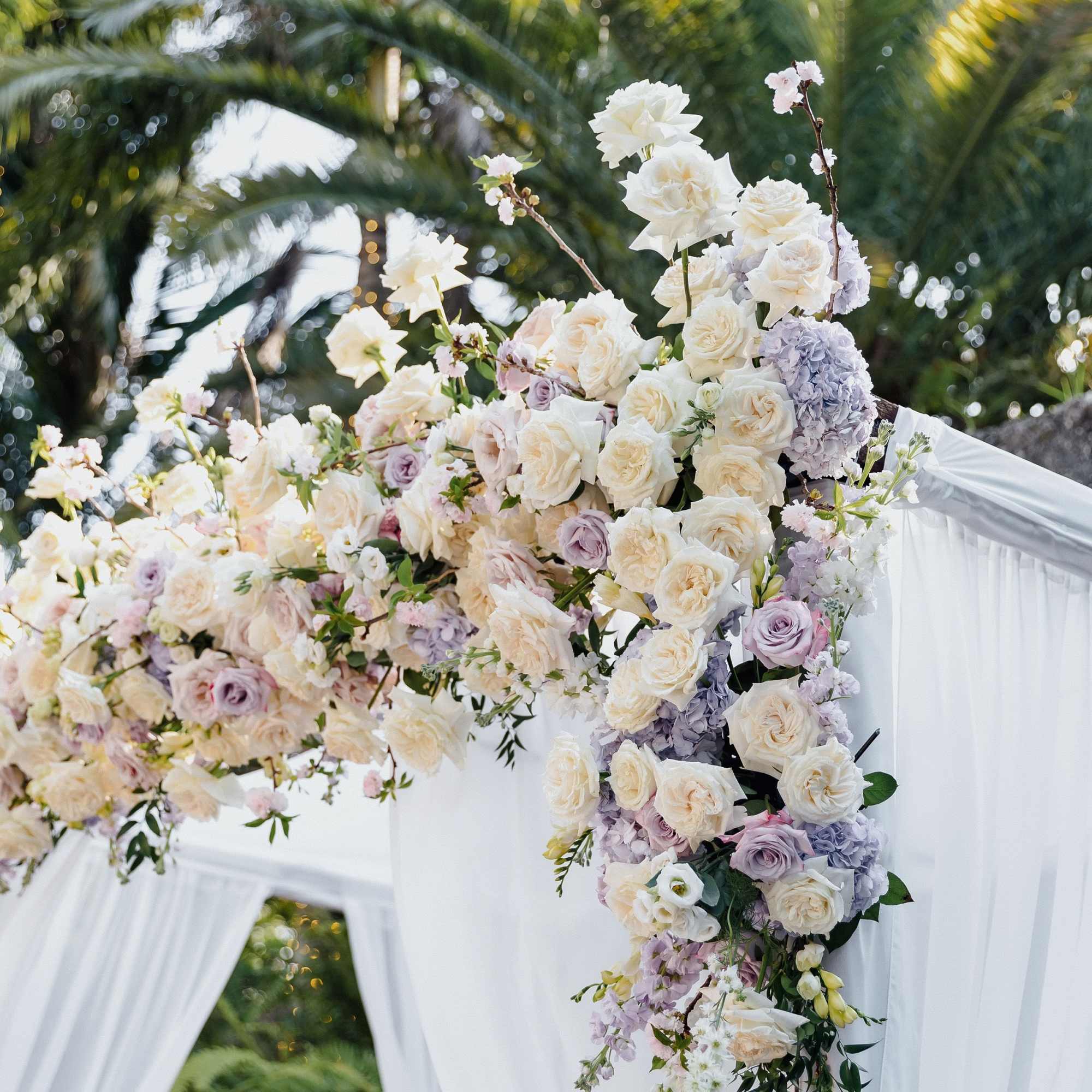 Large white and blush floral wedding arch with cascading blooms